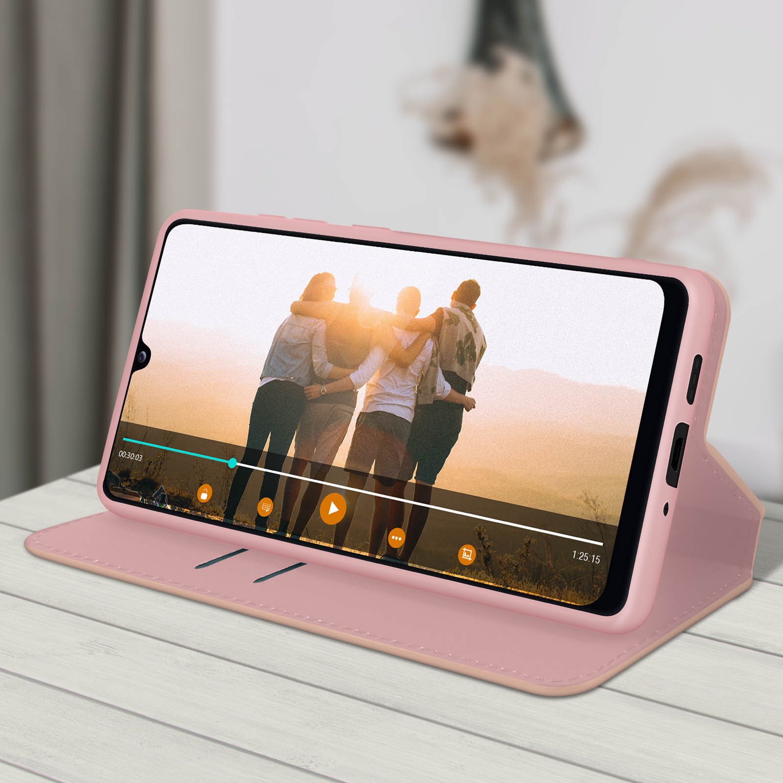 Ein Telefon in einer rosafarbenen Hülle zeigt ein Video. Im Video umarmen sich drei Personen.