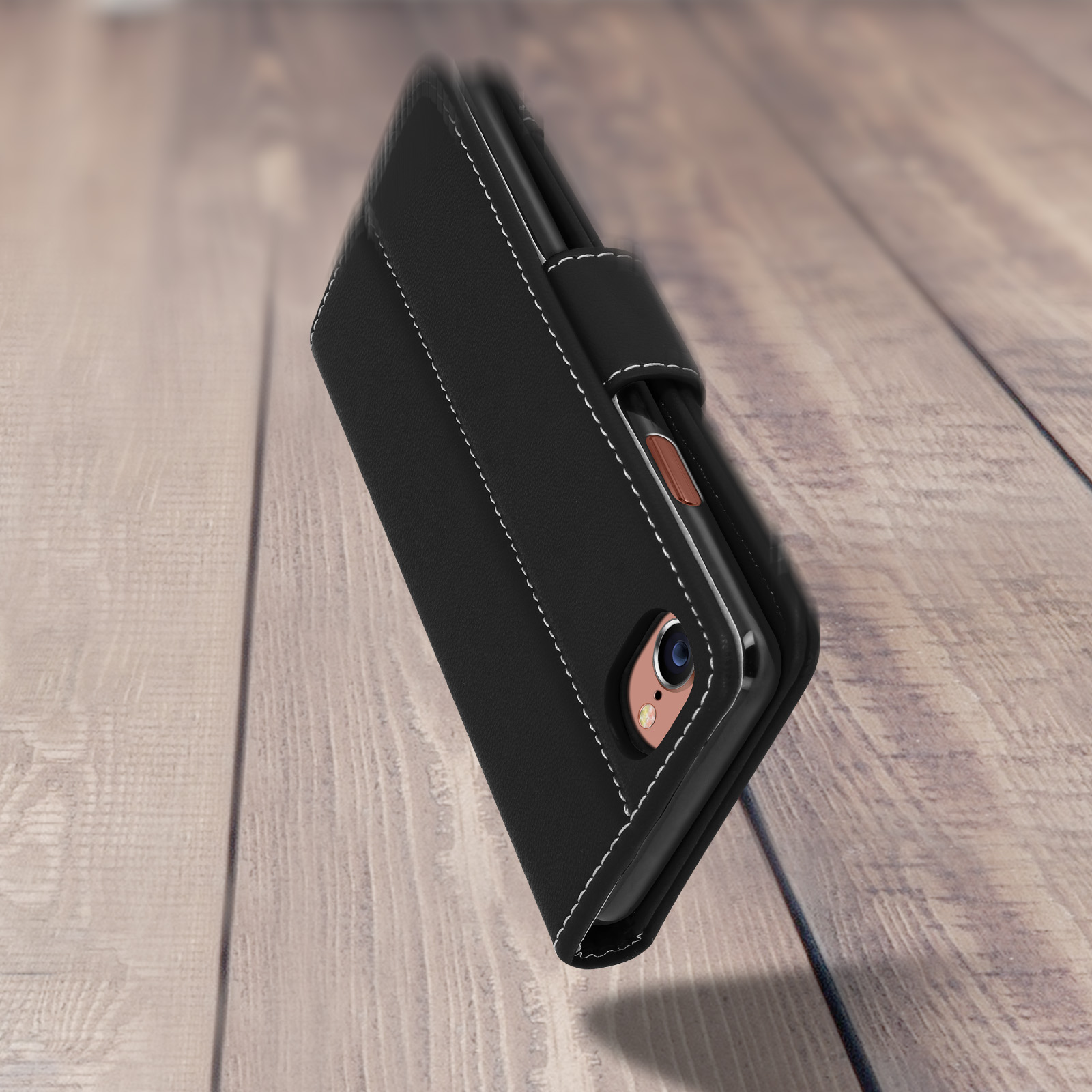 Custodia nera per telefono. È su una superficie di legno. Cuciture bianche attorno al bordo.