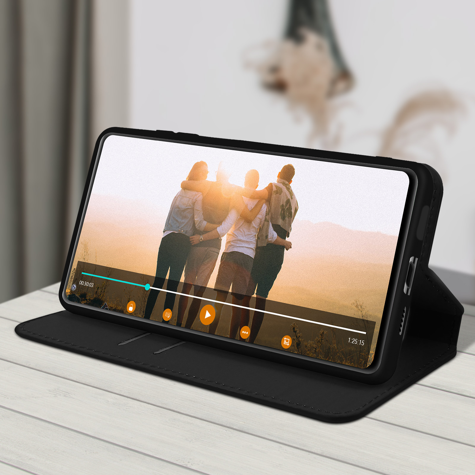 Un étui de téléphone noir est ouvert, montrant un téléphone lisant une vidéo de personnes.
