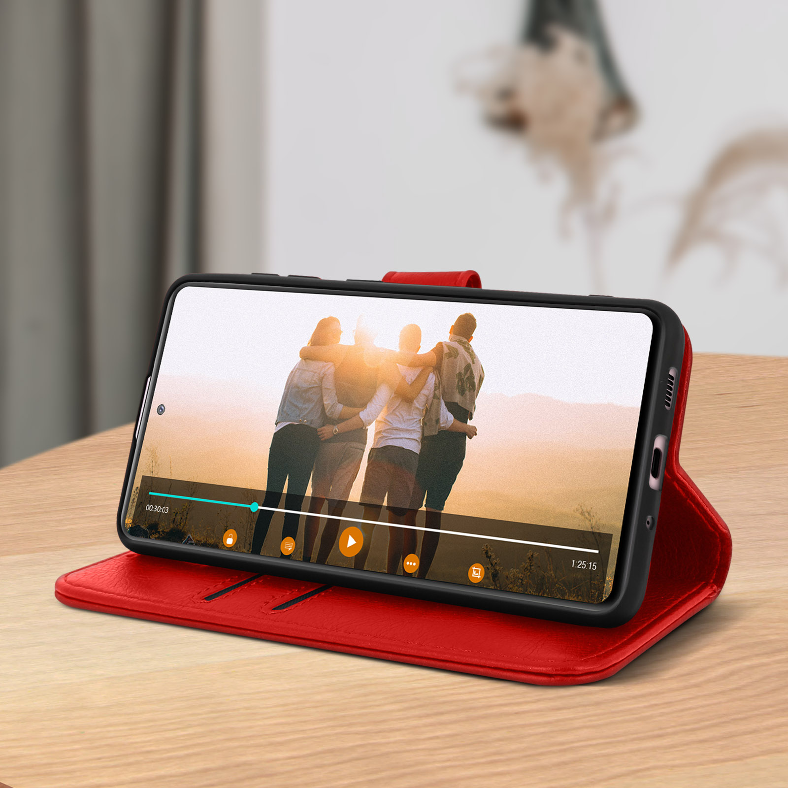 Telefoon in een rode portemonnee-hoes, met een video die wordt afgespeeld. Achtergrond is wazig.