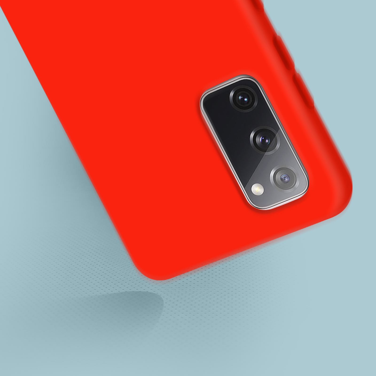 Coque de téléphone rouge avec détail de caméra. Gros plan, fond bleu clair. Focus sur la caméra.
