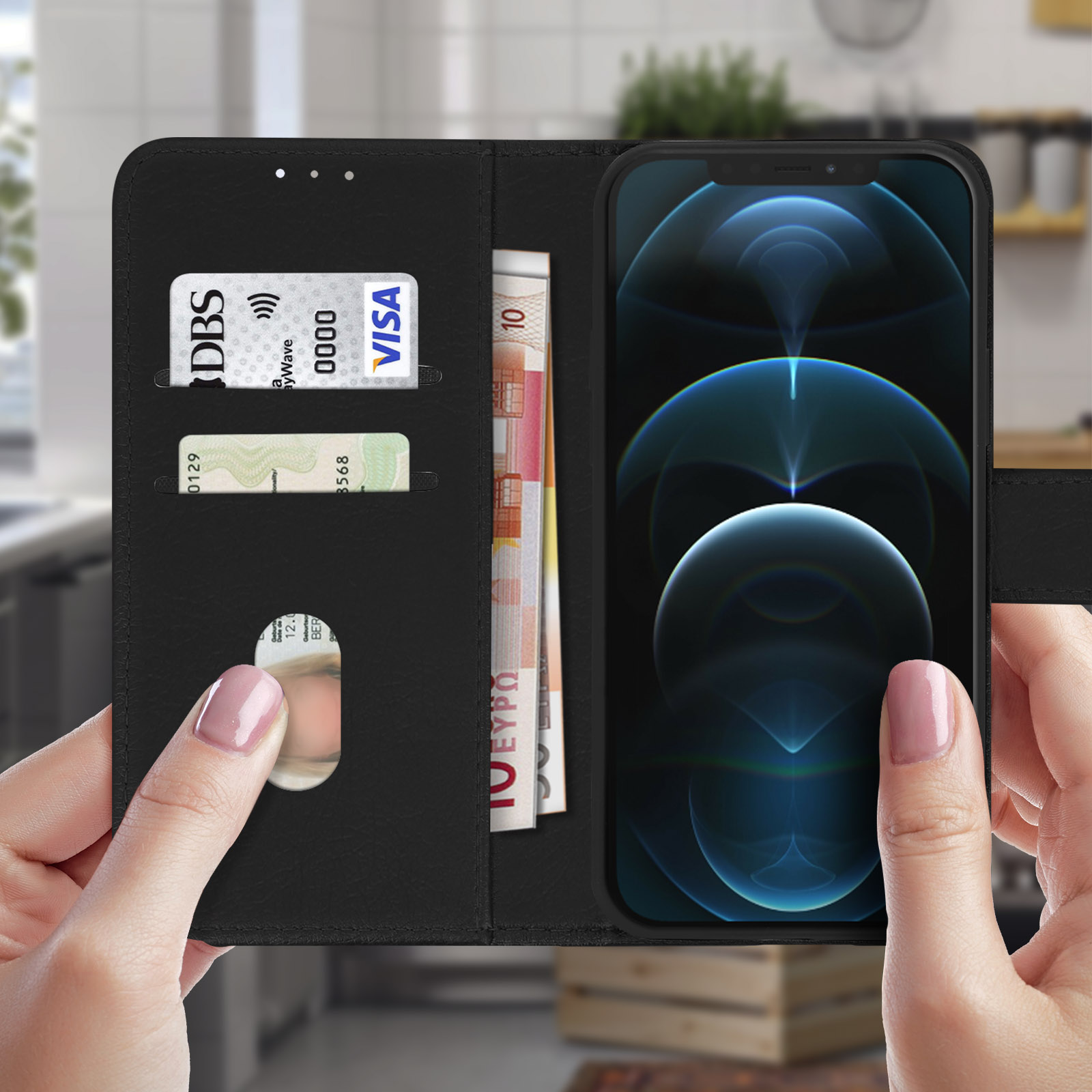 Un portafoglio nero per custodia del telefono con carte e denaro, tenuto in mano.