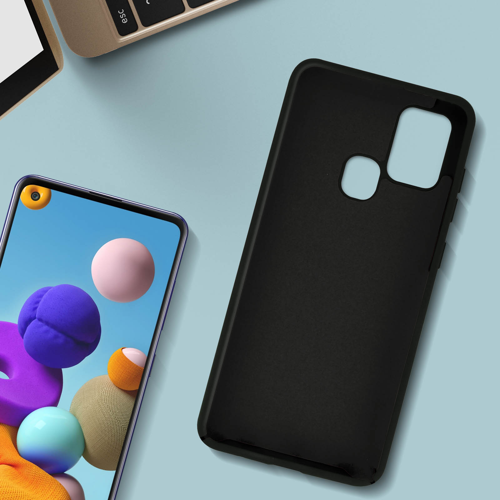 Coque de téléphone noire à côté d'un téléphone. Un ordinateur portable est visible en arrière-plan.