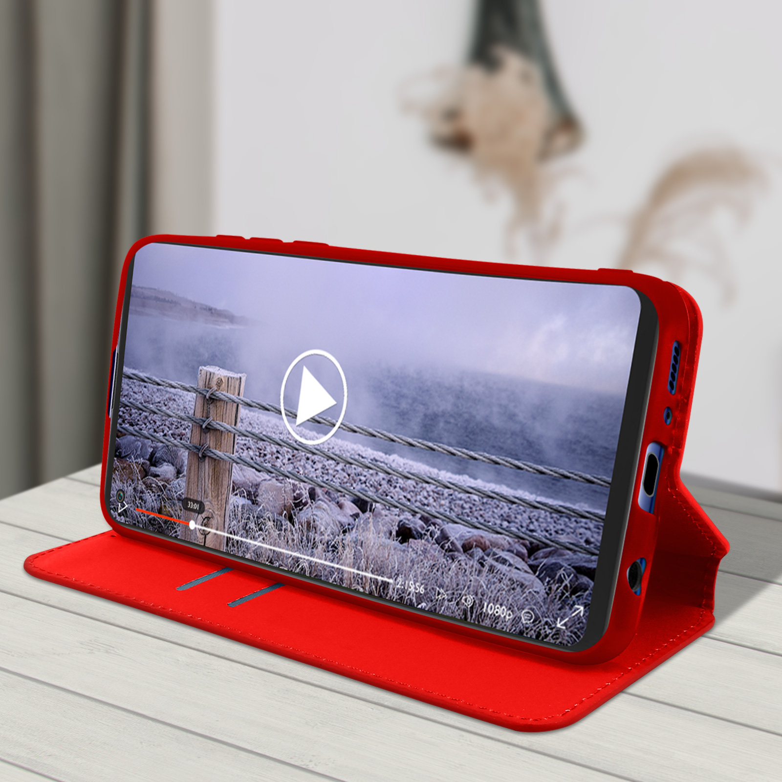 Étui de téléphone rouge avec une vidéo en cours de lecture sur l'écran.