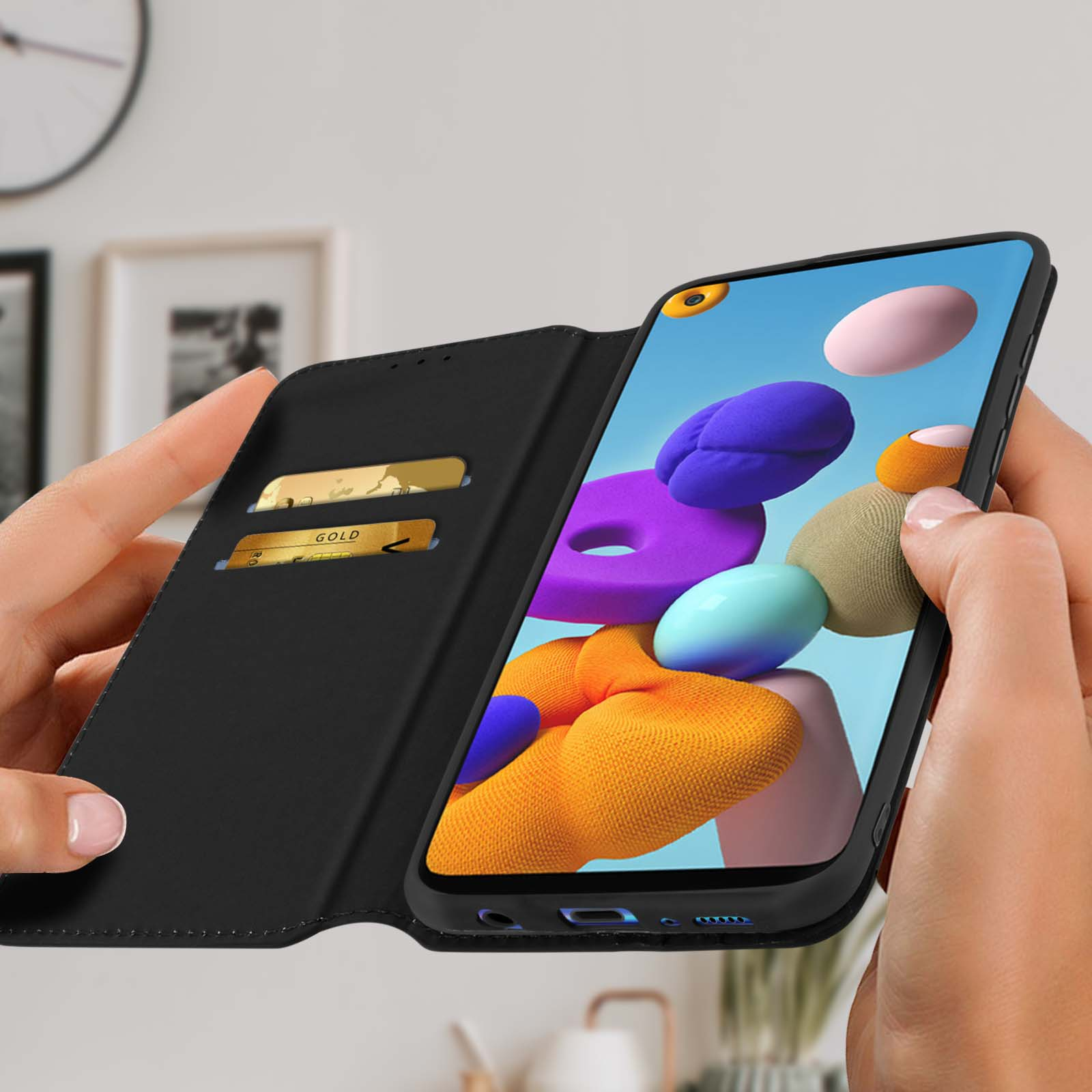 Un téléphone avec un étui noir ouvert avec des cartes de crédit. Le téléphone affiche un fond coloré.