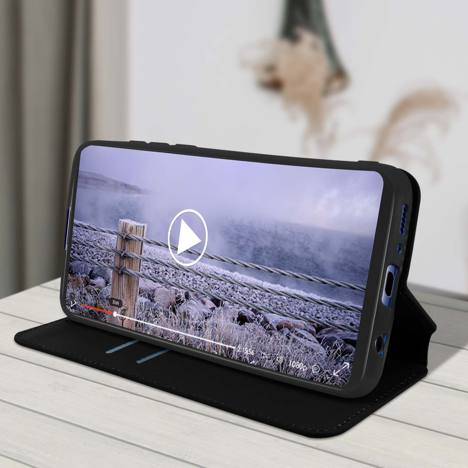 Un téléphone dans un étui affiche une vidéo d'une scène hivernale.