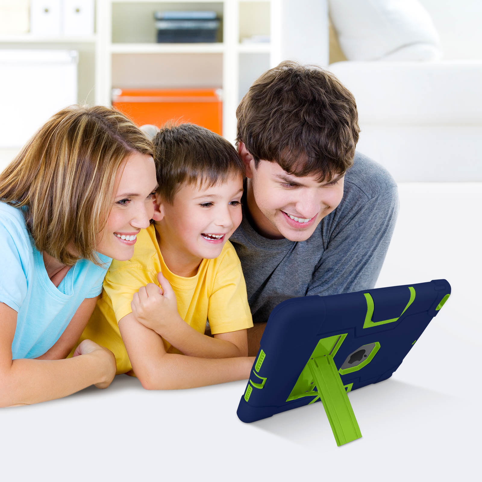 Familie schaut auf ein Tablet mit Hülle. Eine blau-grüne Hülle auf weißer Oberfläche.