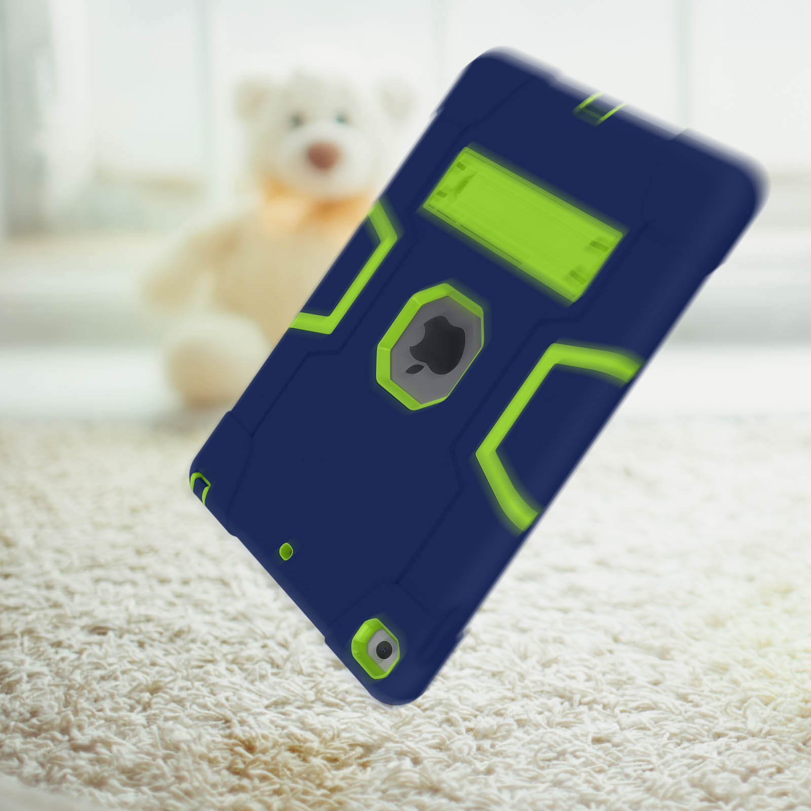 Blau-grüne Schutzhülle für ein Tablet. Ein Teddybär und Teppich sind im Hintergrund.