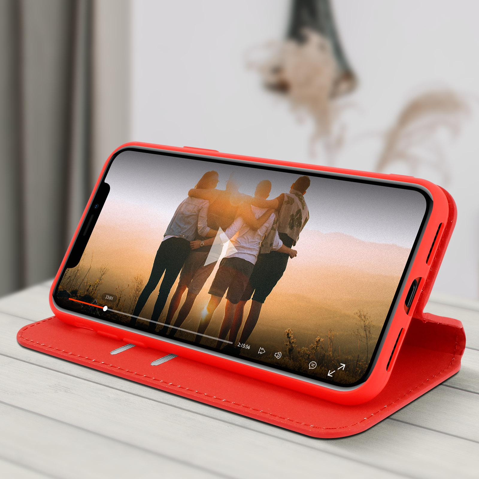 Rode telefoonhoes toont video van mensen op het strand. De hoes ligt op een houten tafel.