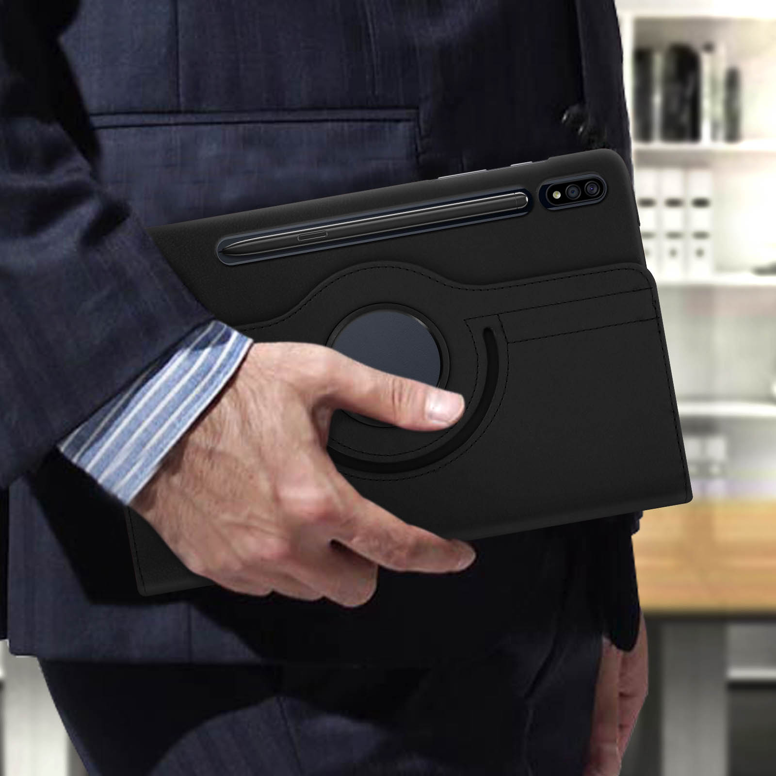 Persona in giacca e cravatta tiene una custodia nera per tablet con anello rotante sul retro.