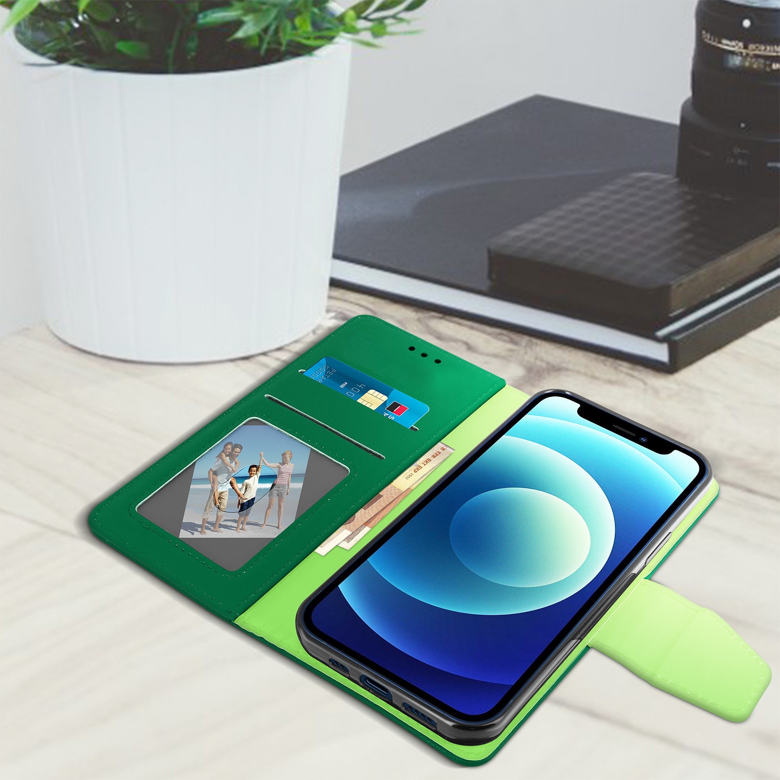 Telefoon in een groene hoes, met kaarten en een foto. Een pen en notitieblok liggen ook op de tafel.