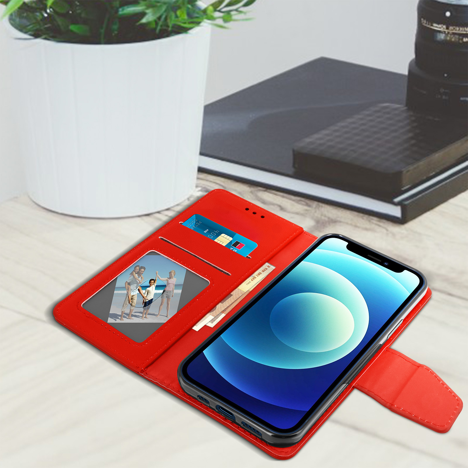 Étui de téléphone rouge ouvert, montrant une photo et une carte. Un téléphone à écran bleu est à l'intérieur.