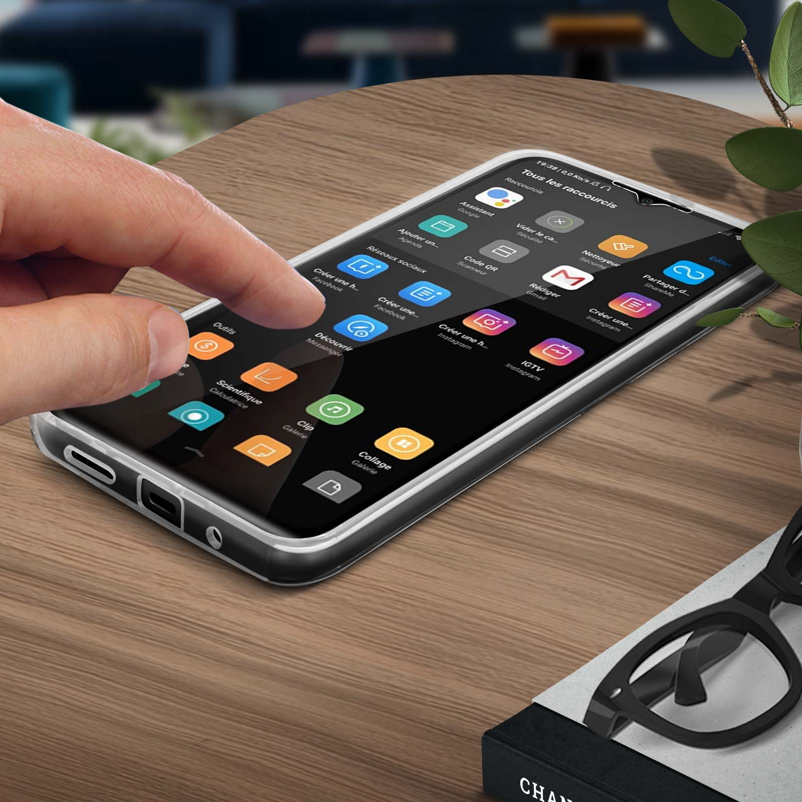 Une main touche un écran de téléphone avec des icônes d'applications. Téléphone sur table en bois.