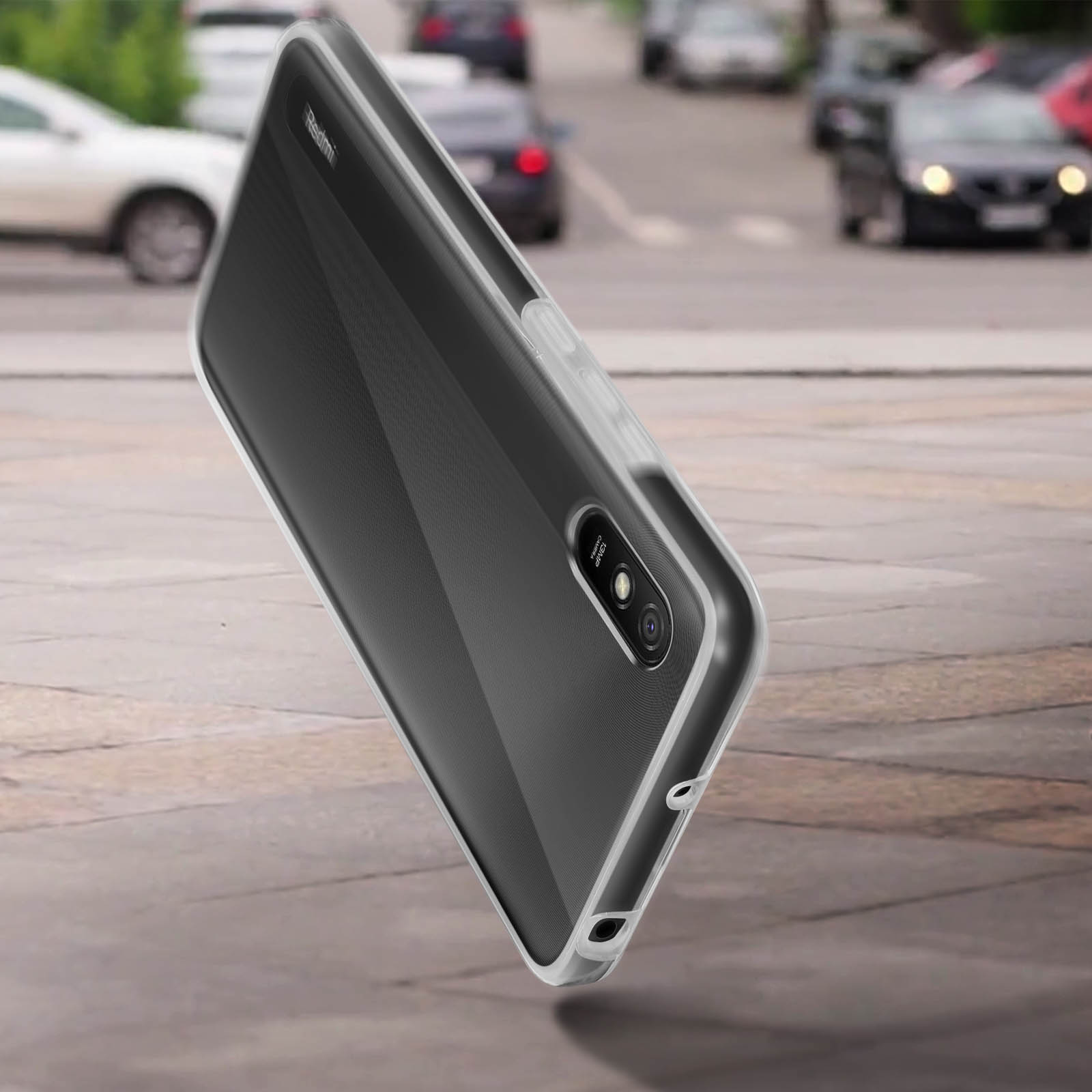 Un téléphone avec une coque transparente dans une rue. Le téléphone est incliné vers la caméra.