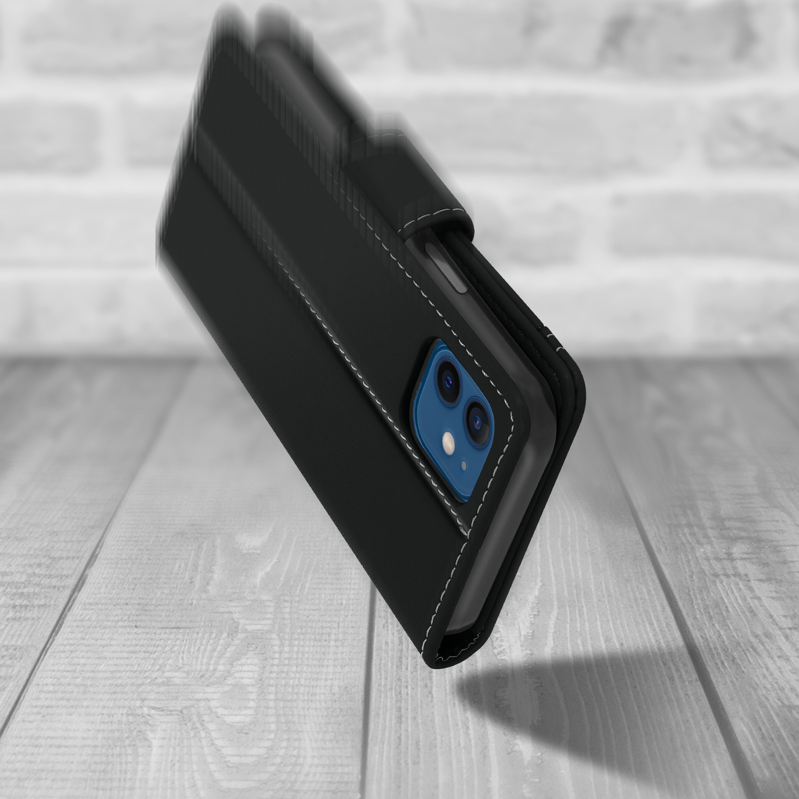 Coque de téléphone noire avec coutures blanches, un téléphone avec des caméras bleues sur fond de bois. L'étui est légèrement ouvert.