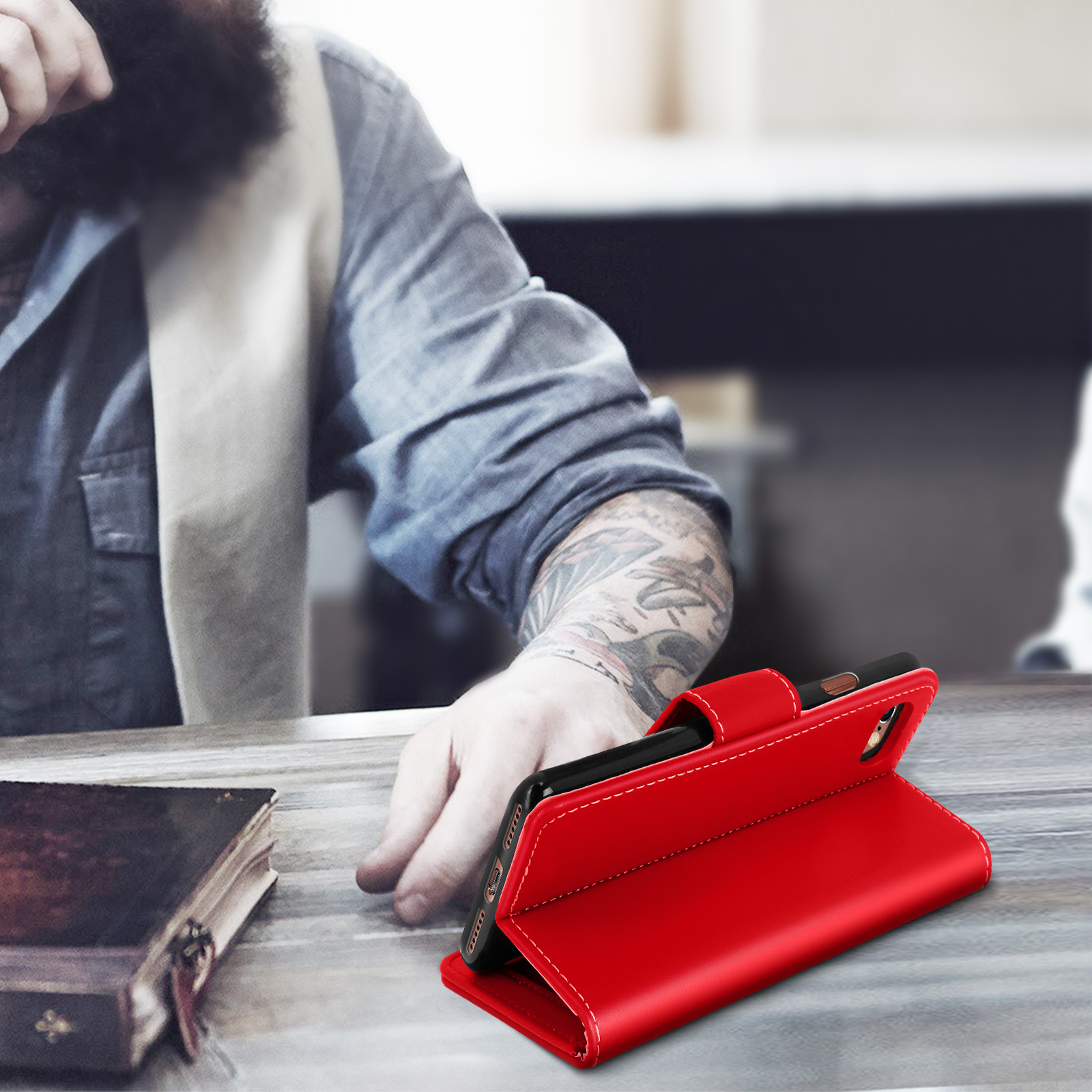 Una custodia per telefono rossa aperta su una scrivania con un uomo sullo sfondo.