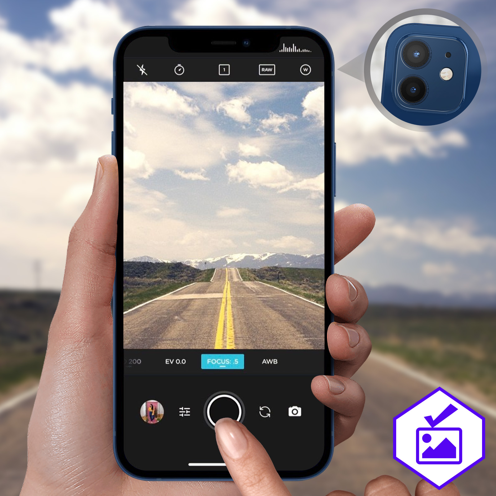 Una mano che tiene un telefono blu. Un'app fotocamera è aperta che mostra una strada con montagne sullo sfondo.