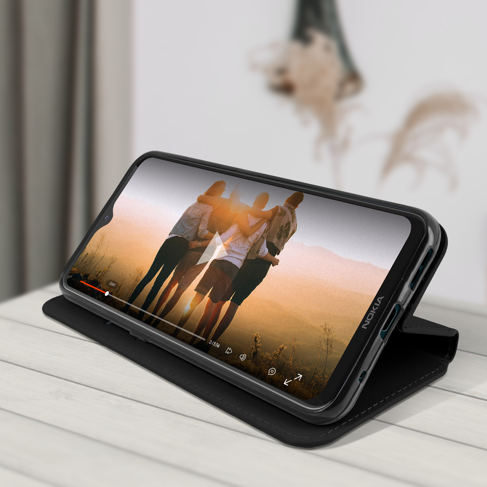 Telefoon in zwarte hoes, met video van mensen. Op houten tafel, zwarte hoes.
