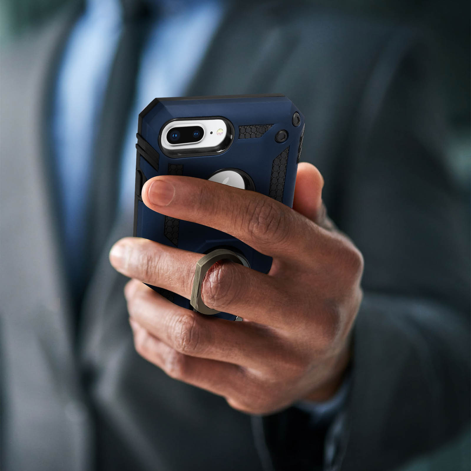 Une main d'homme tenant un étui de téléphone bleu et noir avec une bague.
