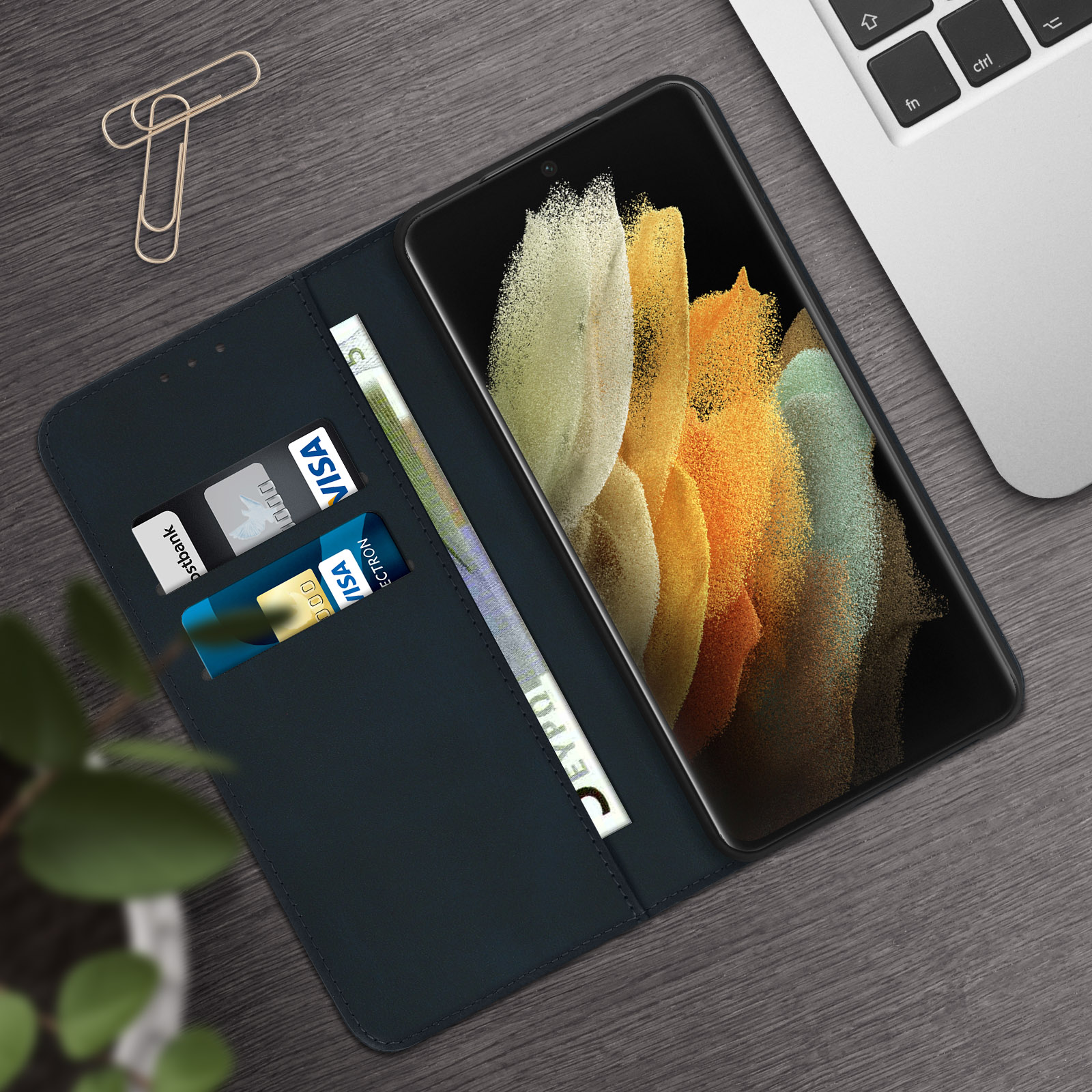 Telefono in custodia con fessure per carte e denaro. Custodia aperta su legno.