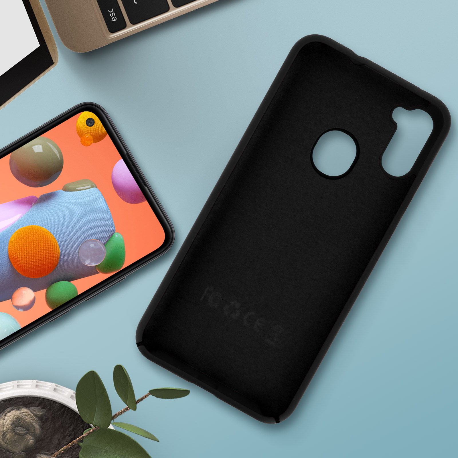 Schwarze Handyhülle, Telefonbildschirm sichtbar. Orange und pinke Grafik, blauer Hintergrund.