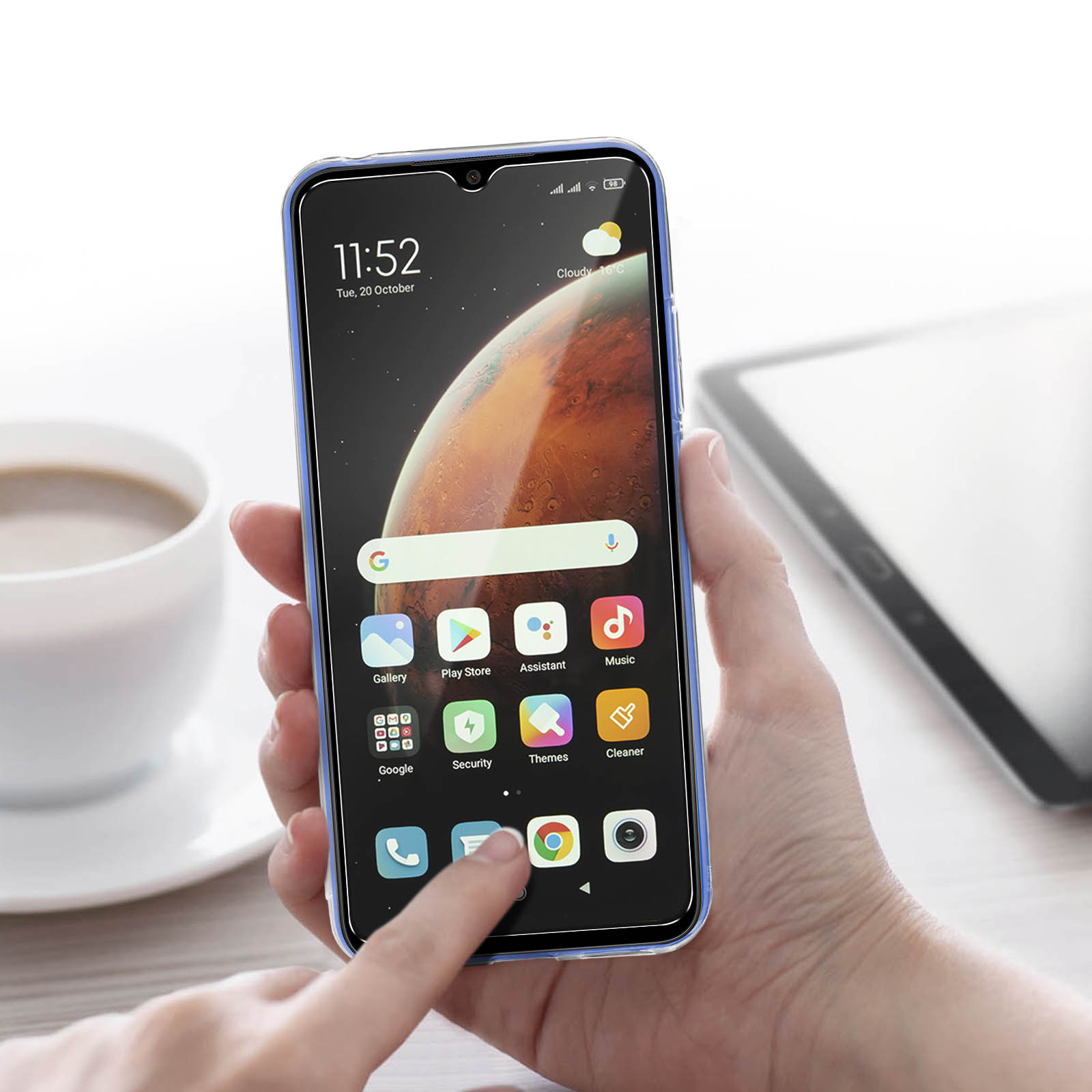 Una mano che tiene un telefono con protezione per lo schermo, che mostra app e un orologio.