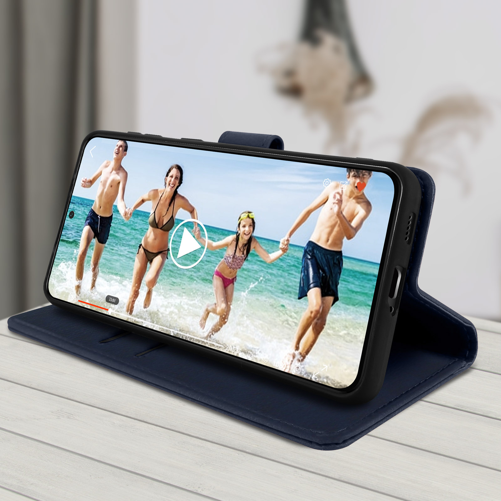 Telefono che mostra video di persone in acqua, in custodia blu su tavolo.