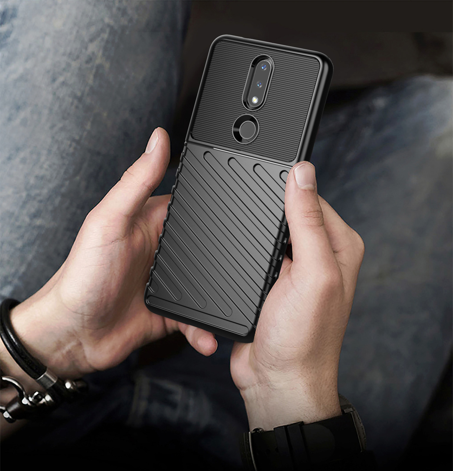Una persona che tiene un telefono con una custodia nera. La custodia ha un design strutturato.