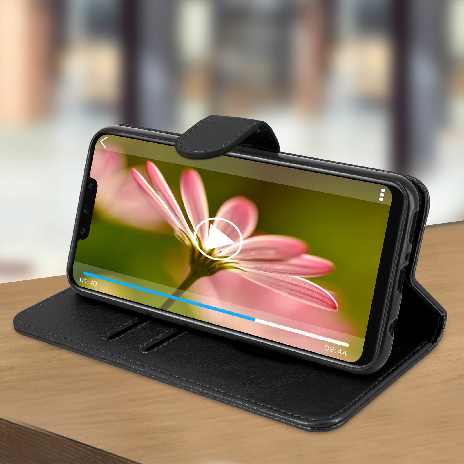 Custodia del telefono aperta, che mostra video. Custodia nera, su superficie di legno, con pulsante play.