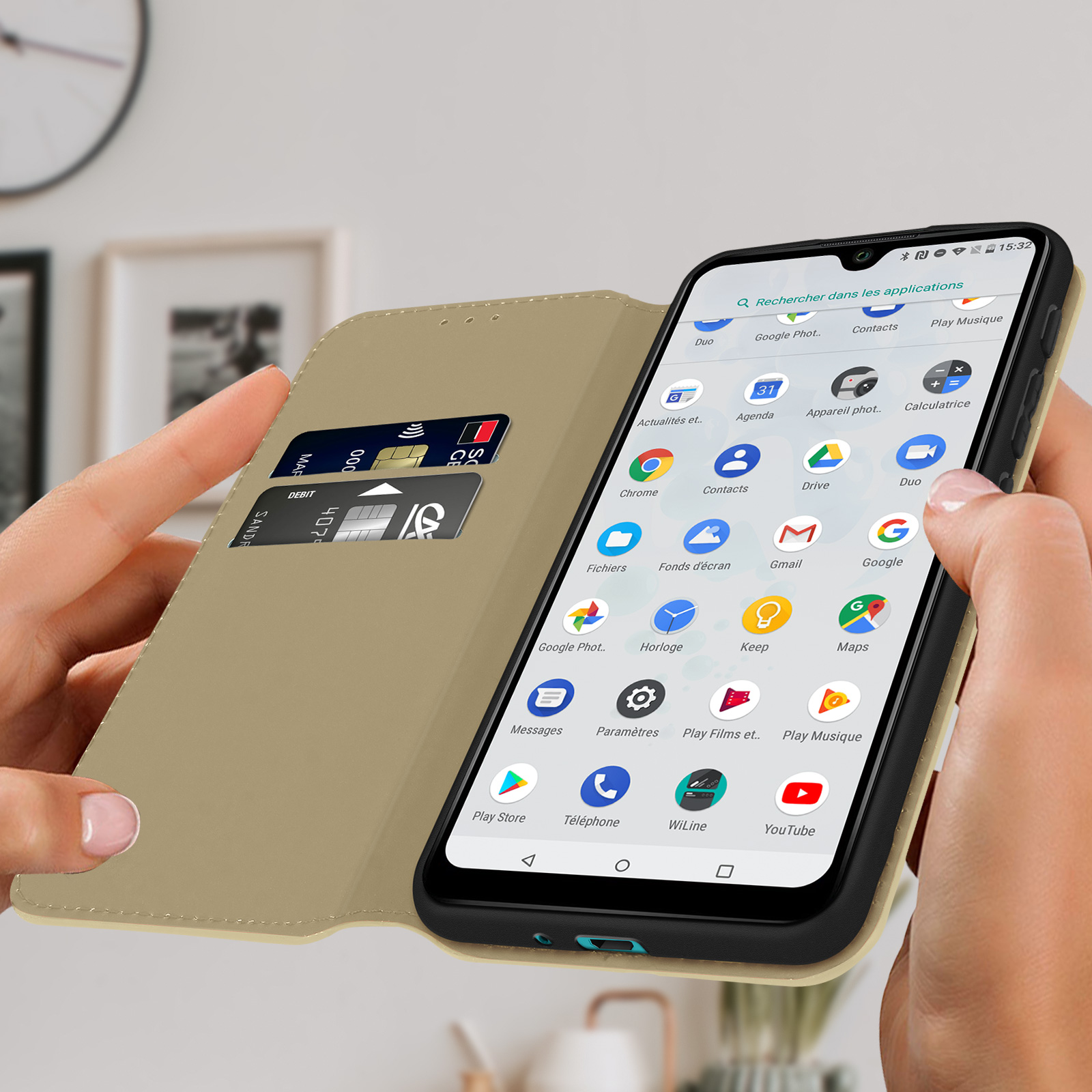 Custodia beige, aperta, telefono che mostra la schermata dell'app. Sfondo: oggetti sfocati.