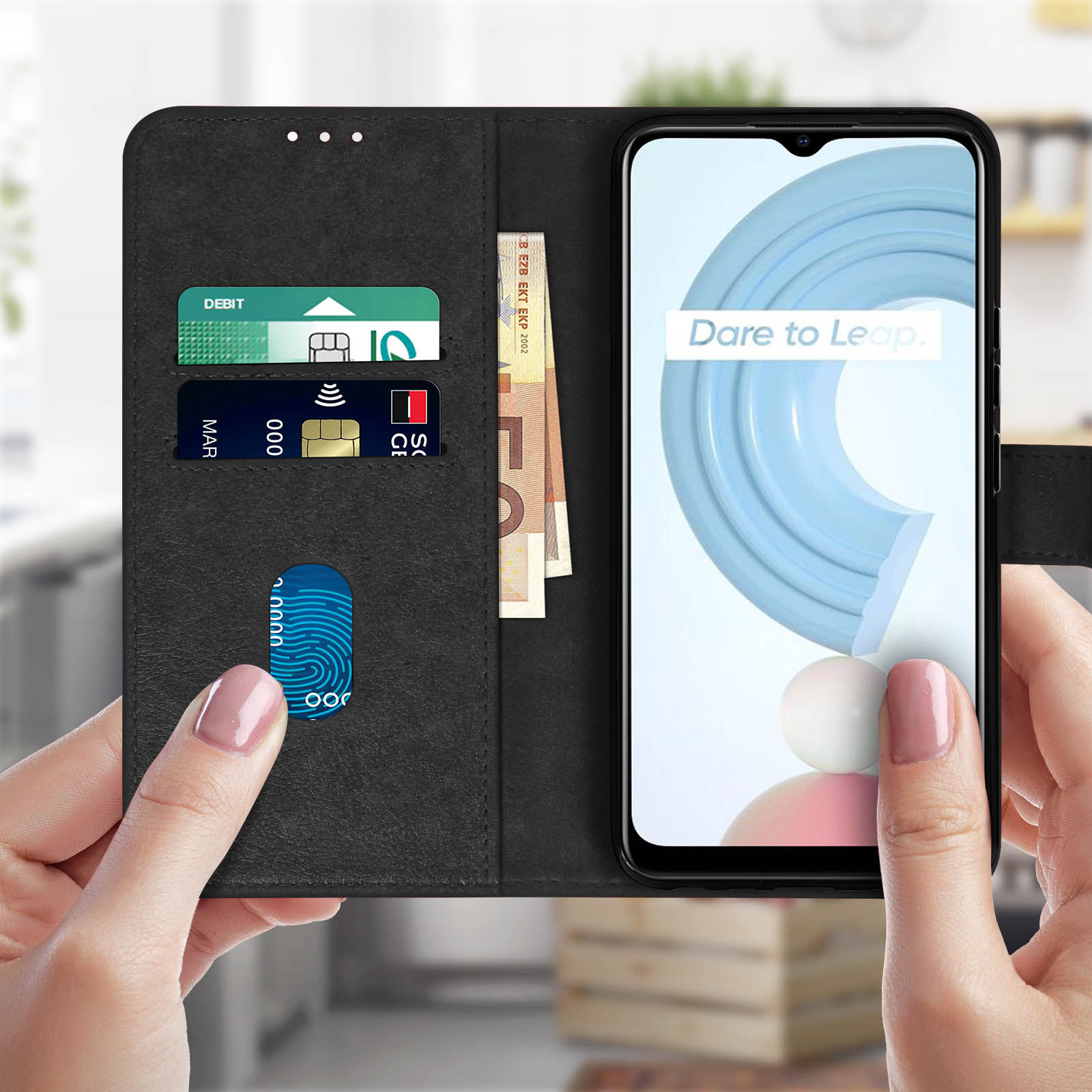 Una custodia per telefono nera aperta, con carte e denaro all'interno. Un telefono mostra un design blu e bianco.