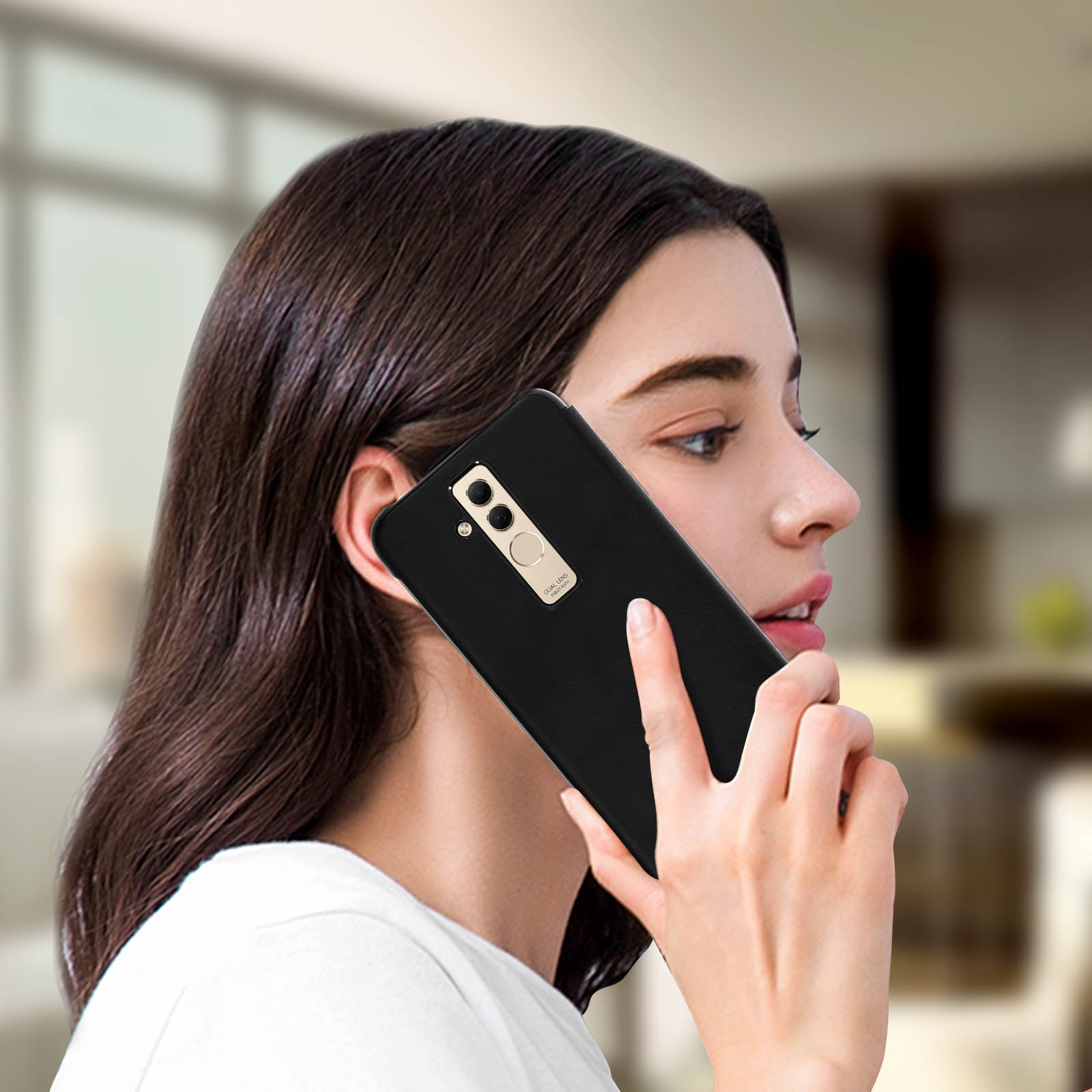 Una donna tiene un telefono all'orecchio. È in un ambiente domestico.
