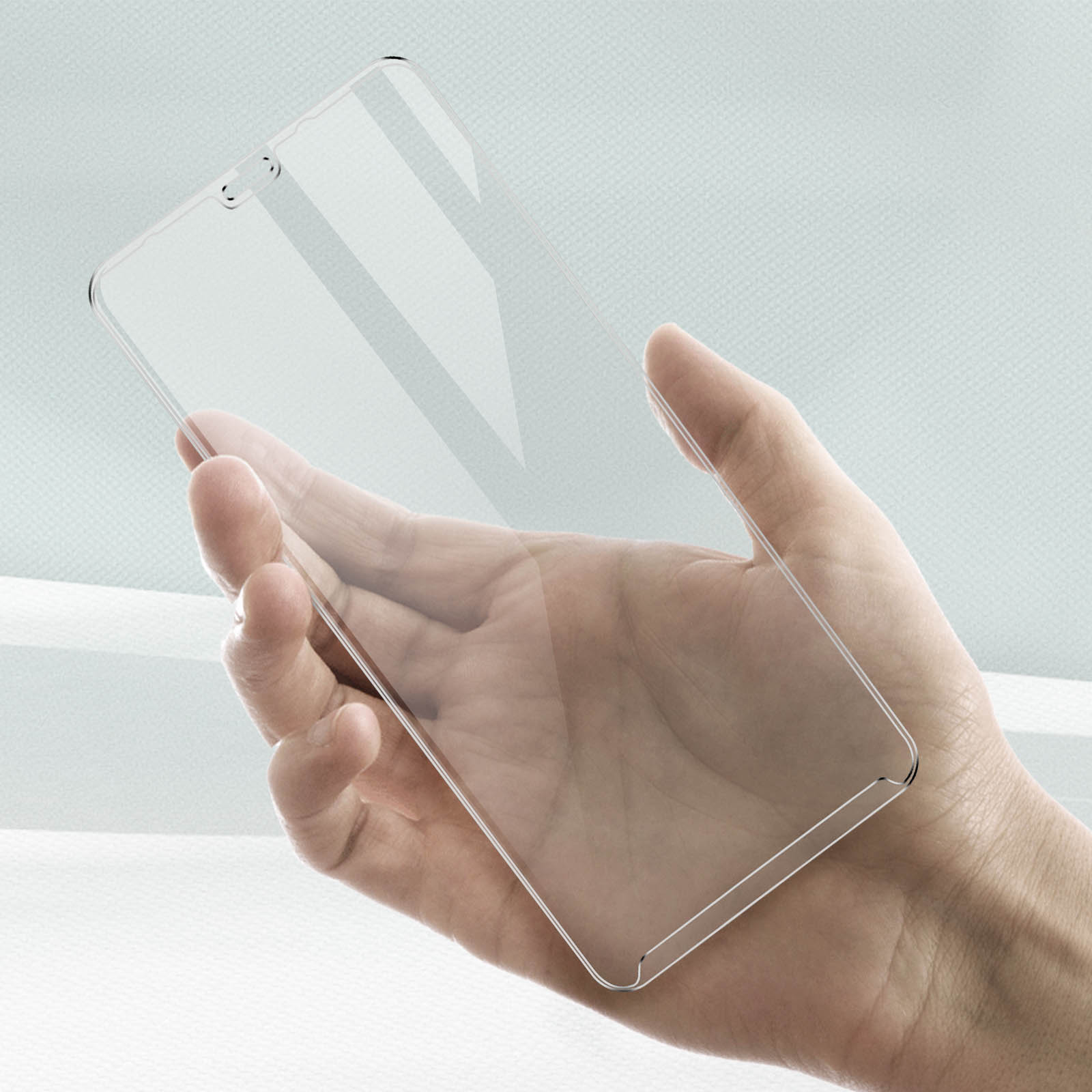 Una mano tiene in mano una protezione per lo schermo trasparente per telefono.