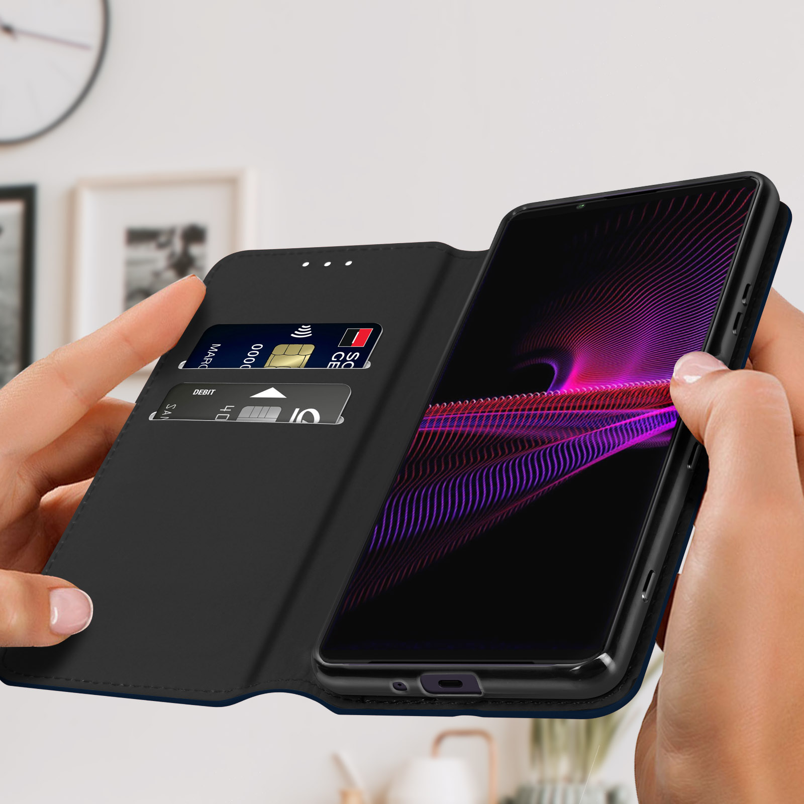 Mani che tengono un telefono con custodia aperta. Carte di credito nello slot. Il telefono mostra un'immagine colorata.
