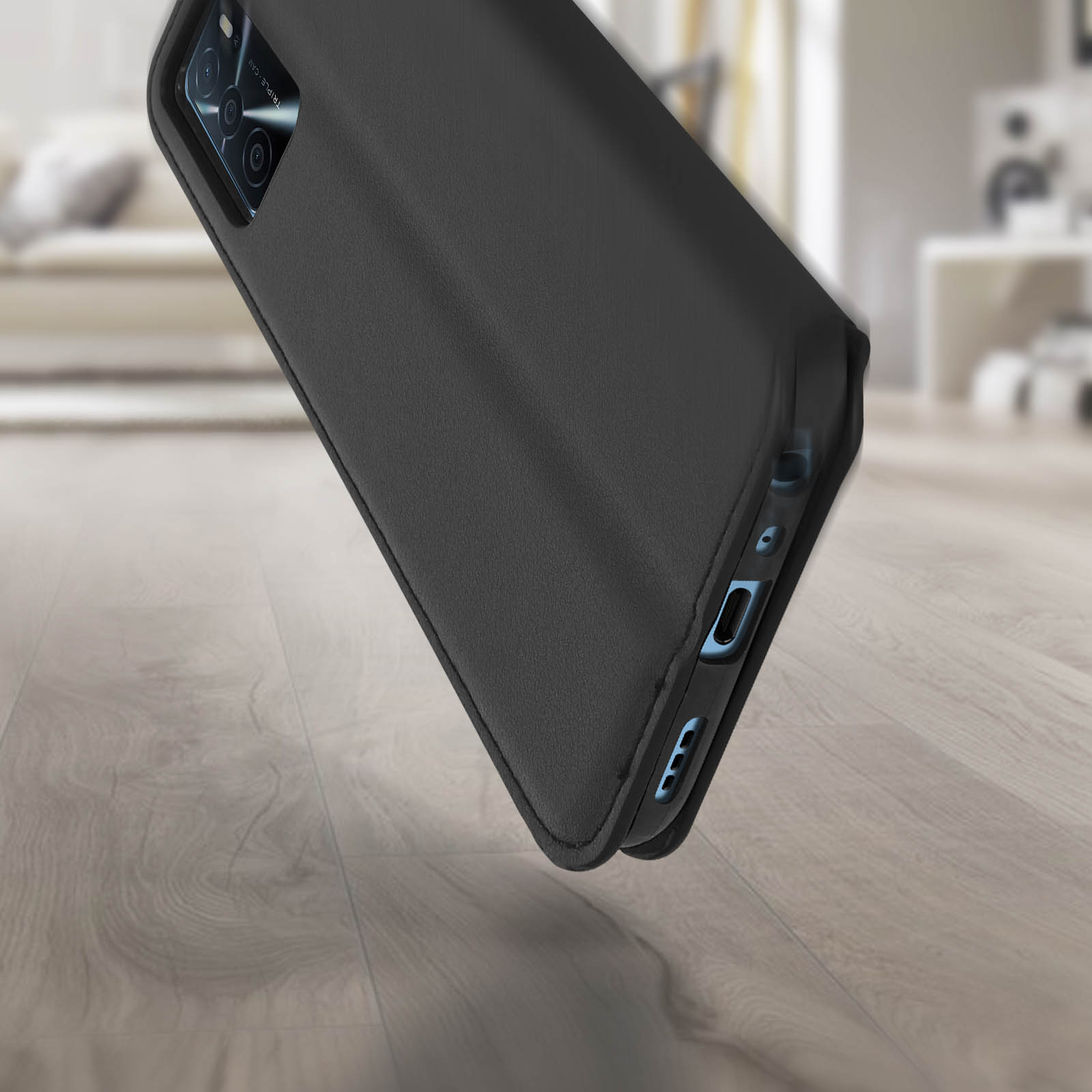 Un téléphone dans un étui noir fermé est légèrement incliné. L'étui est sur une surface en bois.