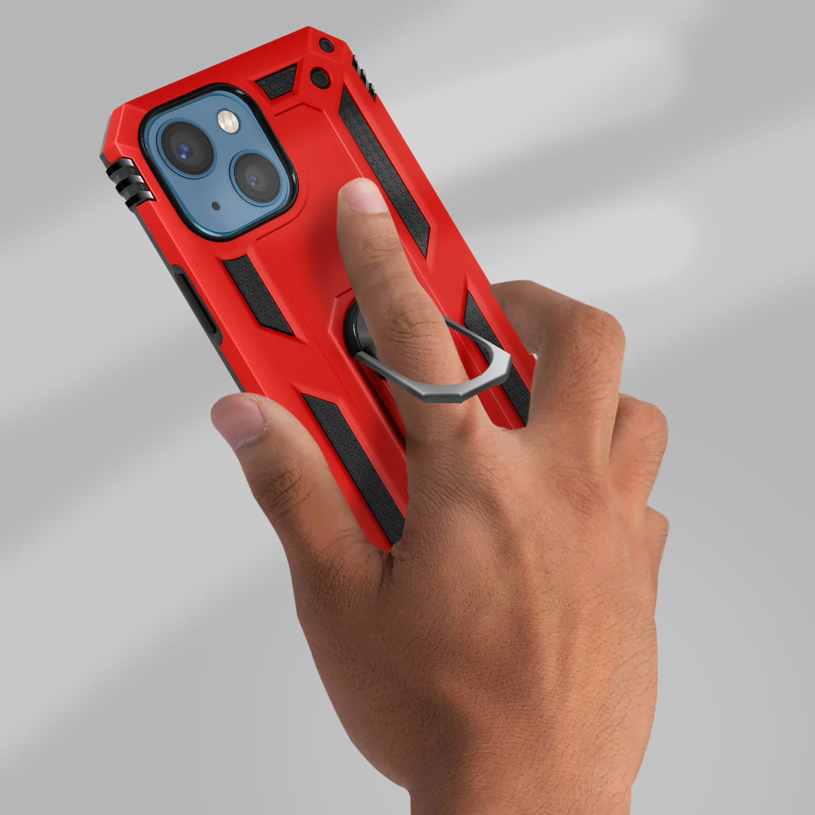 Una mano tiene una custodia rossa per telefono con un anello. Lo sfondo è grigio chiaro.