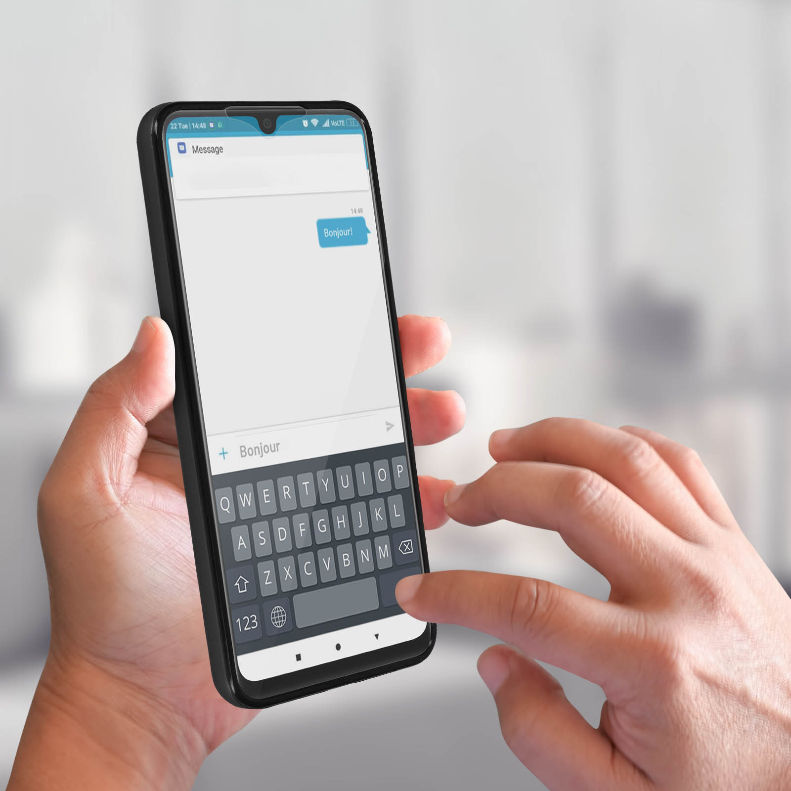 Una mano che tiene un telefono con un messaggio sullo schermo. Il testo dice "Bonjour!".