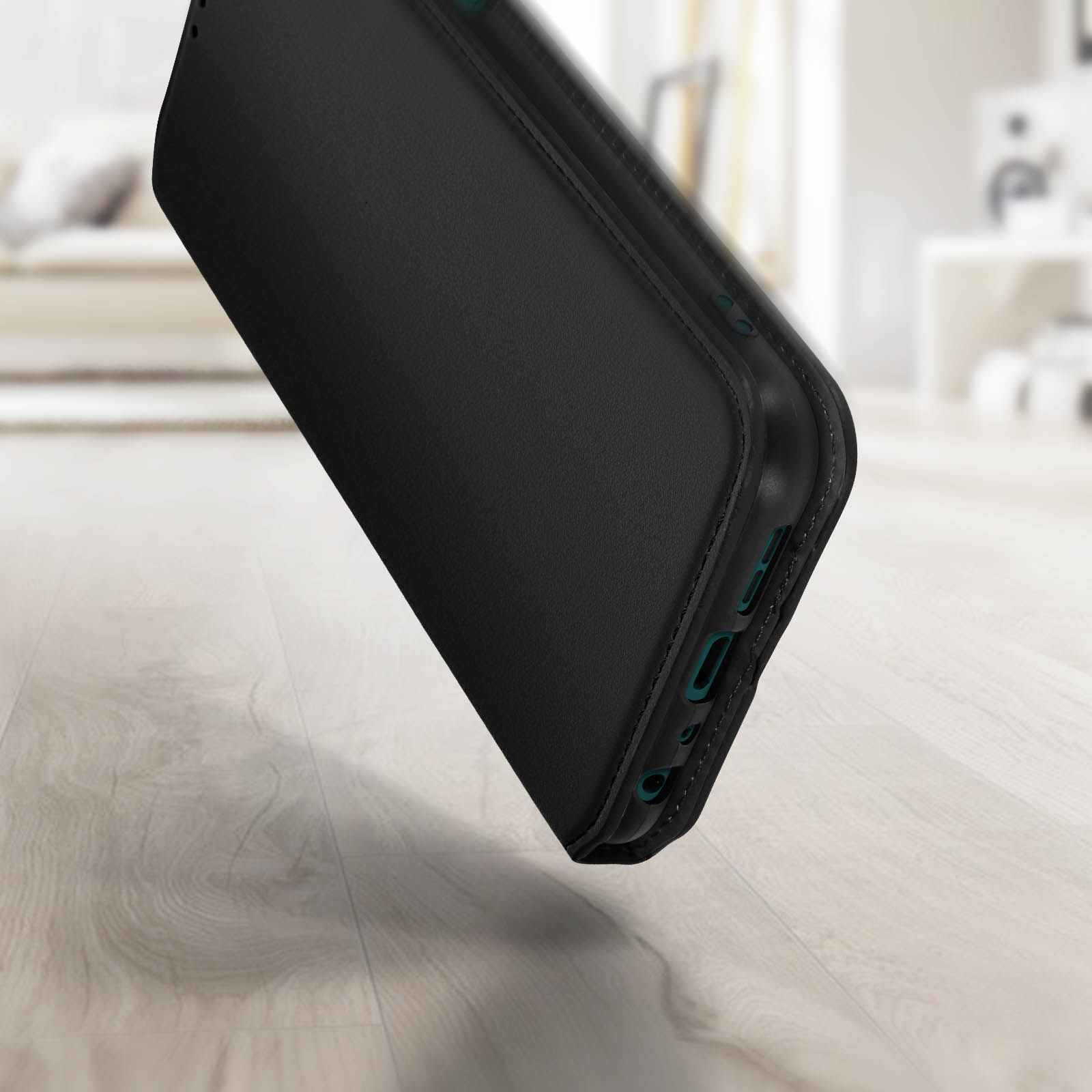 Custodia nera per telefono. Il telefono è dentro. La custodia è leggermente inclinata. Pavimento in legno e sfondo sfocato.