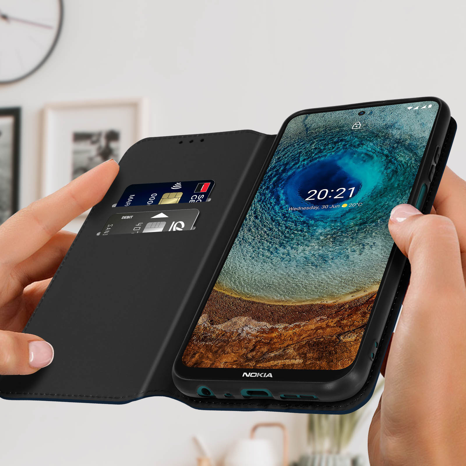Mani che tengono un telefono in una custodia nera, che mostra lo schermo e le carte.