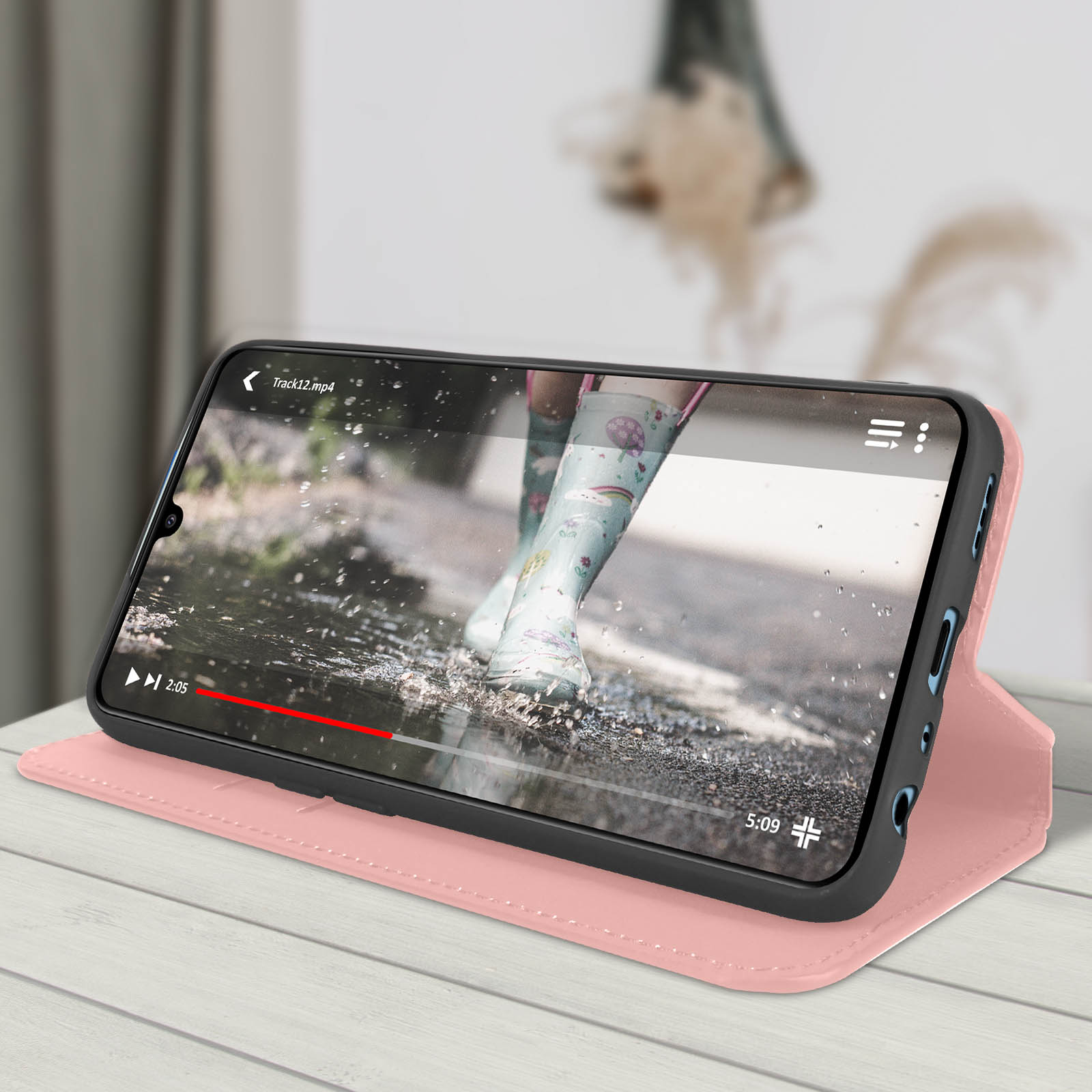 Telefono in custodia rosa con video di bambino che cammina sotto la pioggia. Custodia aperta.