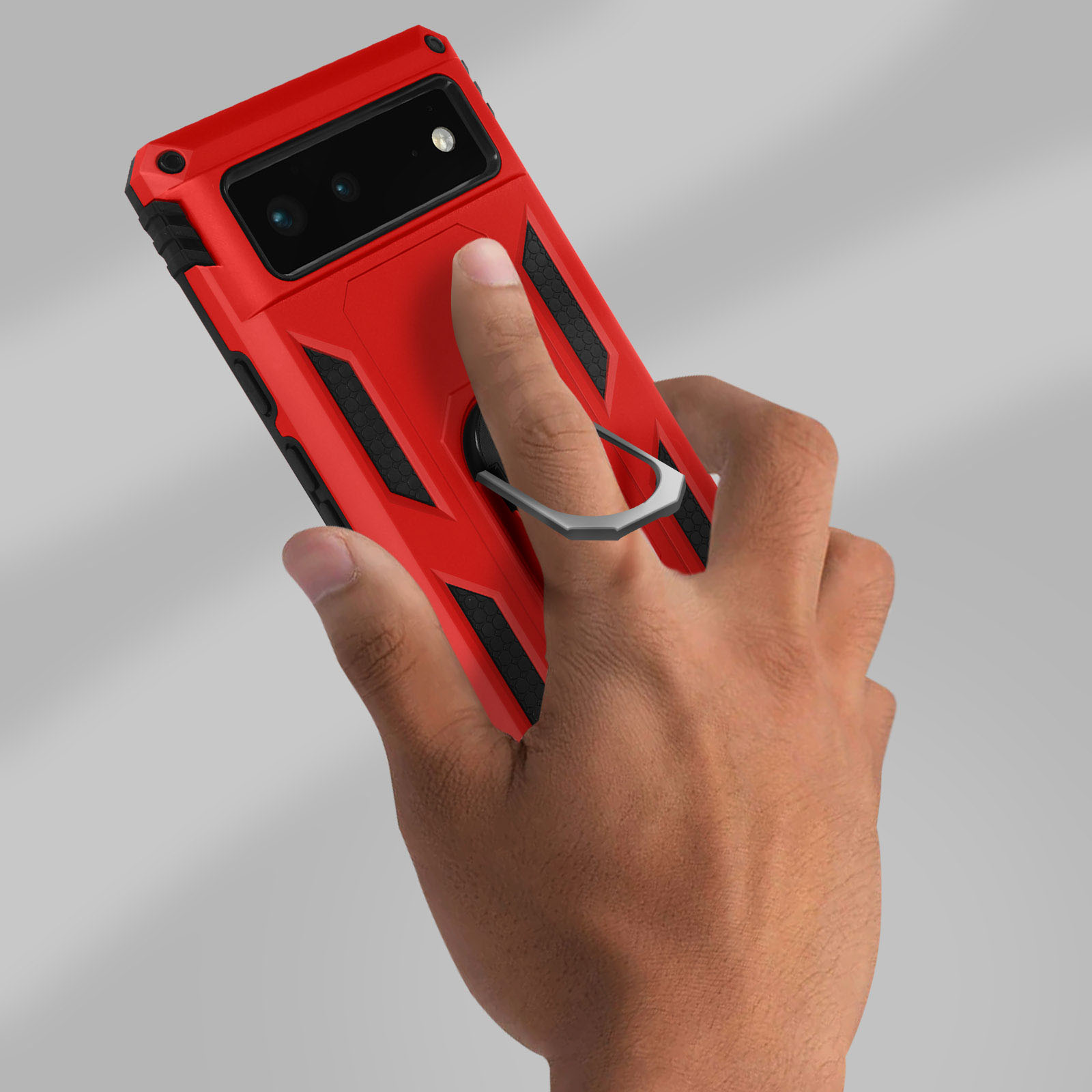 Una mano che tiene una custodia rossa per telefono con un anello, su sfondo grigio.