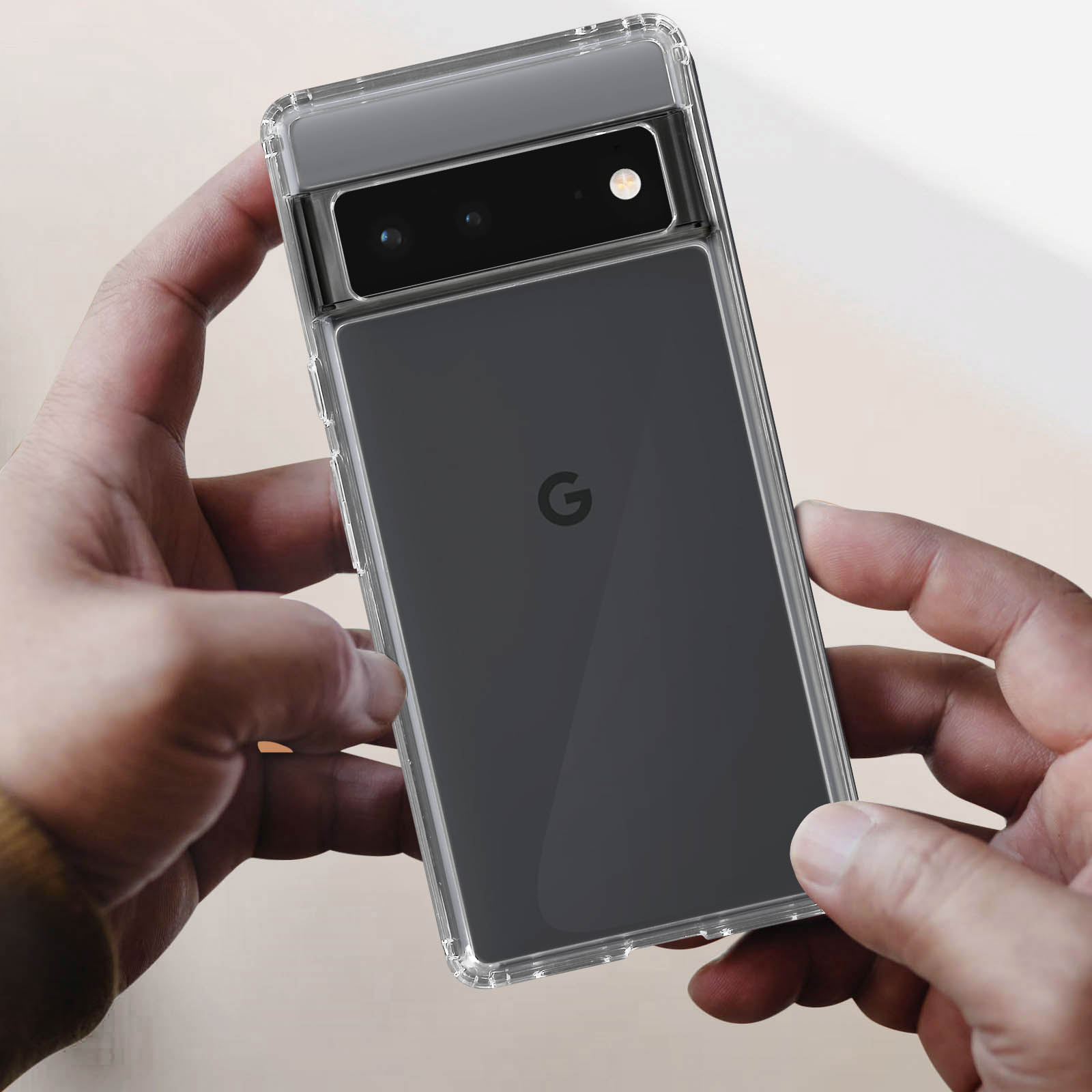 Mani che tengono un telefono in una custodia trasparente. Il telefono ha il logo Google sul retro.