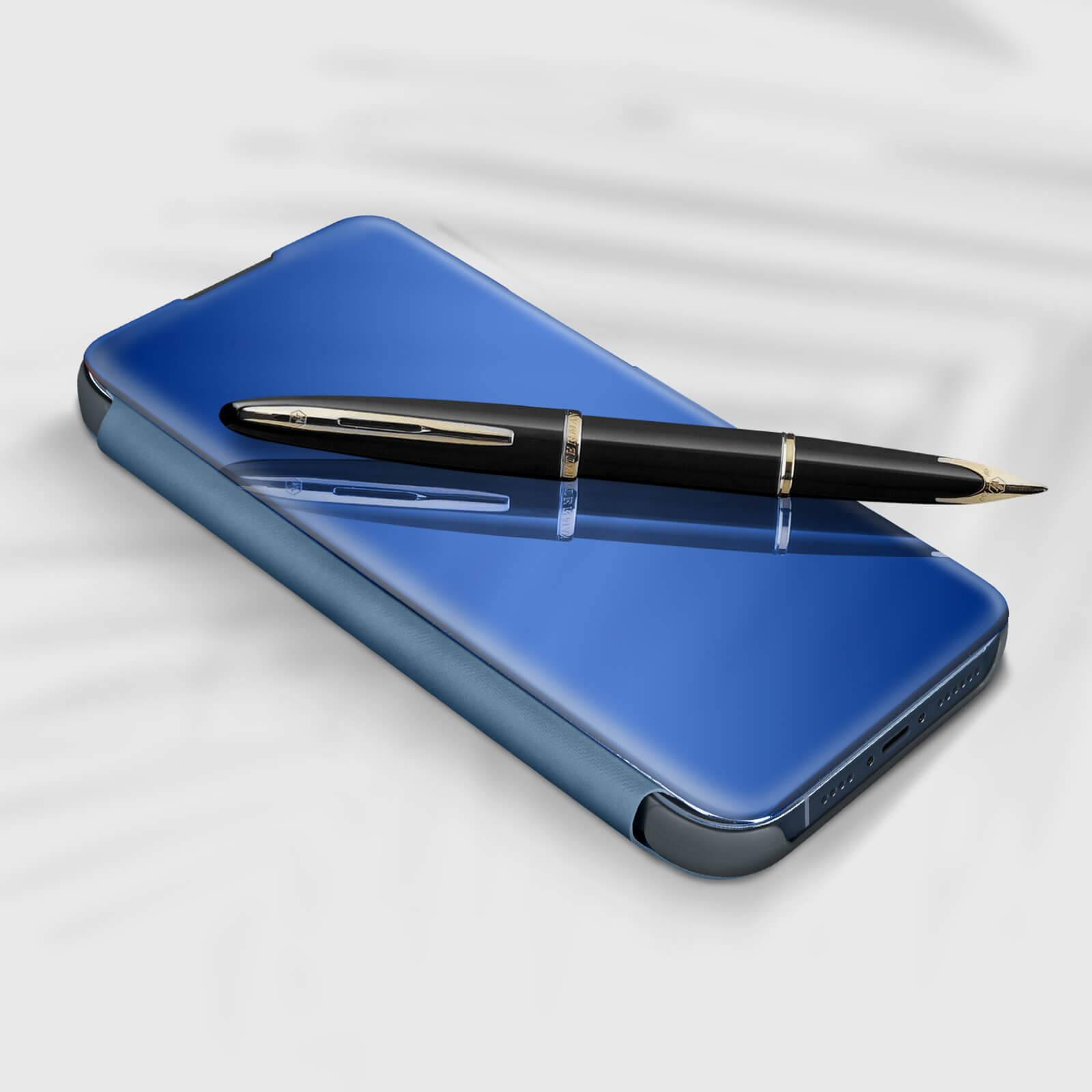 Custodia per telefono blu con una penna nera sopra. La penna ha una fascia dorata ed è nera.