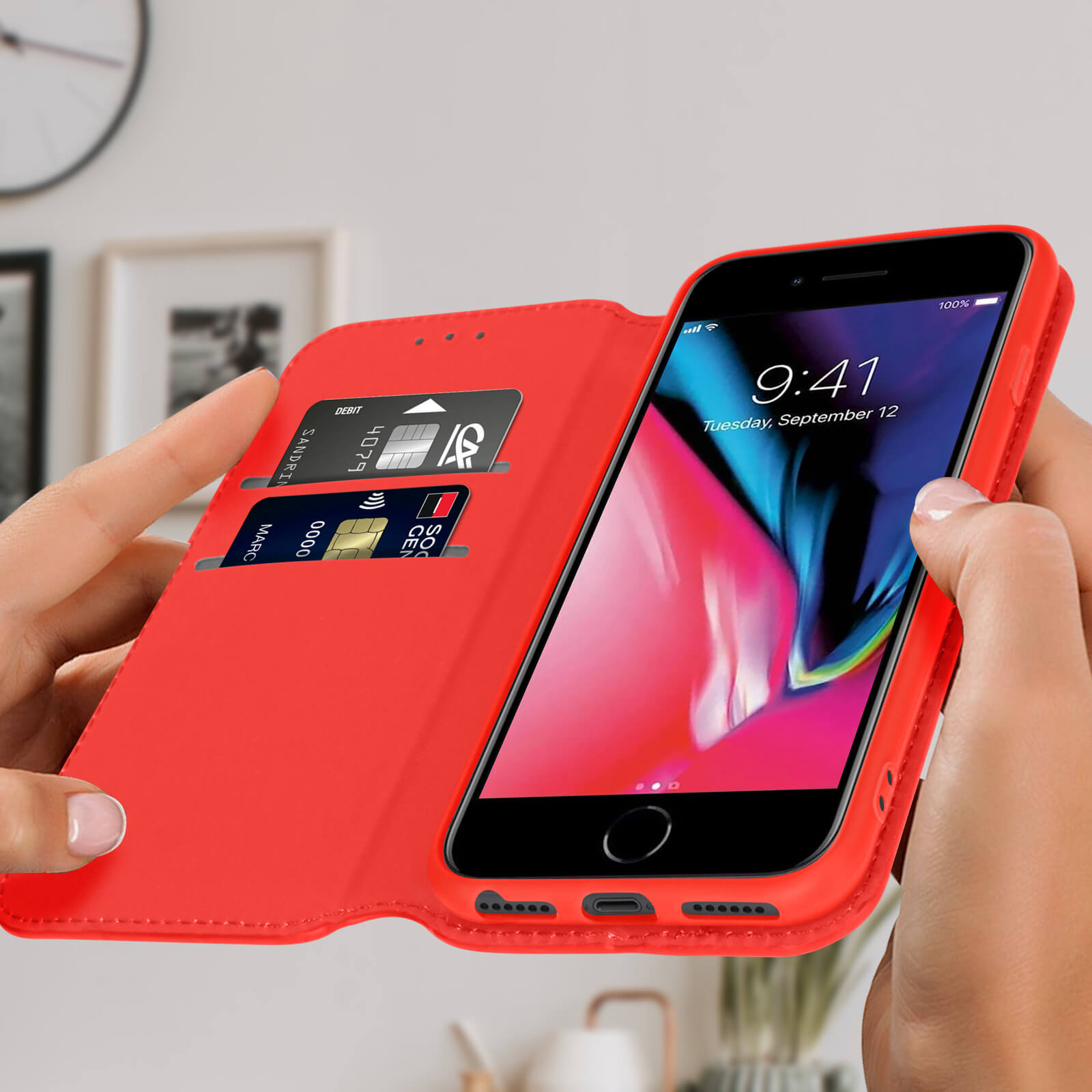 Mains tenant un étui rouge avec un téléphone à l'intérieur, montrant l'écran. Cartes visibles.