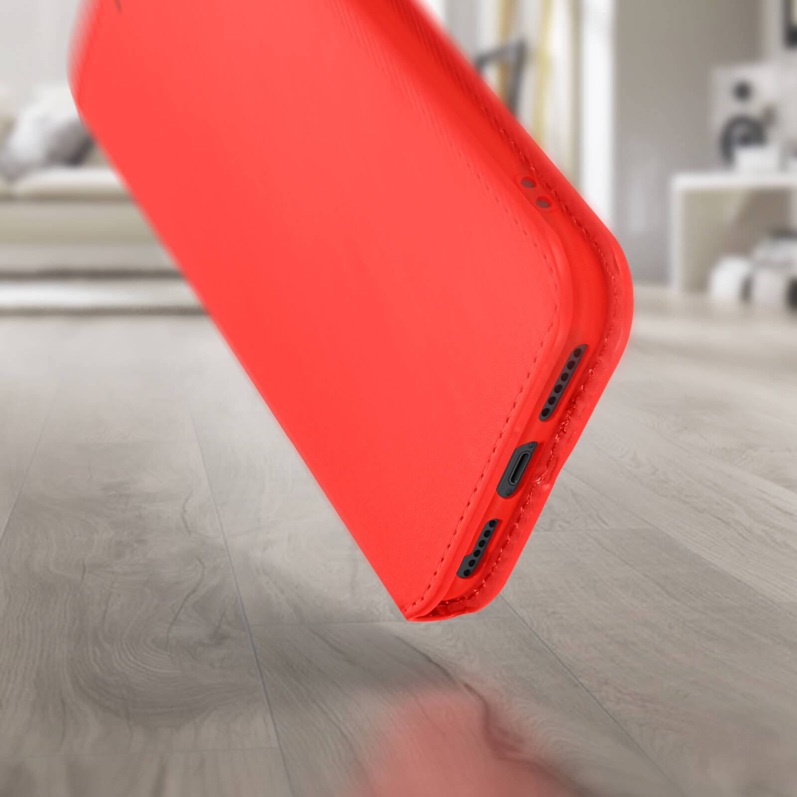 Étui de téléphone rouge incliné, montrant le côté avec boutons et port de charge.
