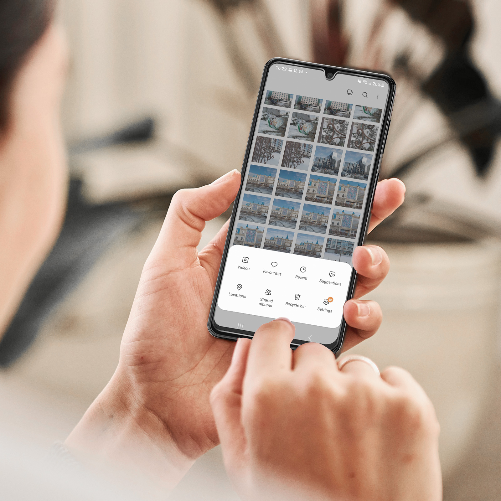 Una persona che tiene in mano un telefono che mostra un'app di galleria. Lo schermo mostra le foto.