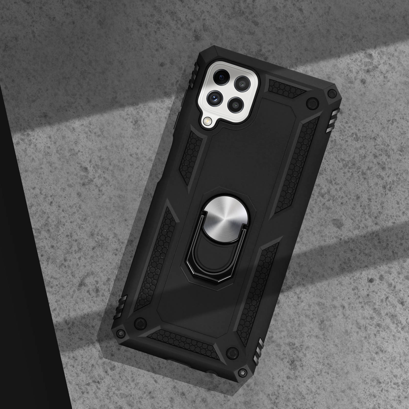 Zwarte telefoonhoes op een grijs oppervlak. De hoes heeft een ringstandaard en een verhoogd gedeelte rond de camera.
