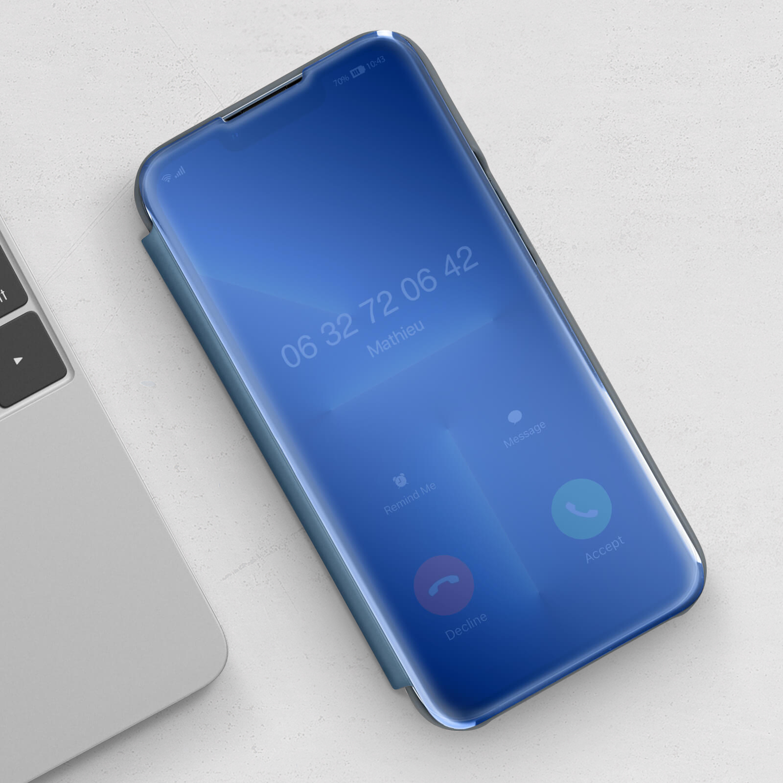Un telefono che mostra uno schermo blu con opzioni di chiamata. Un laptop è accanto al telefono.