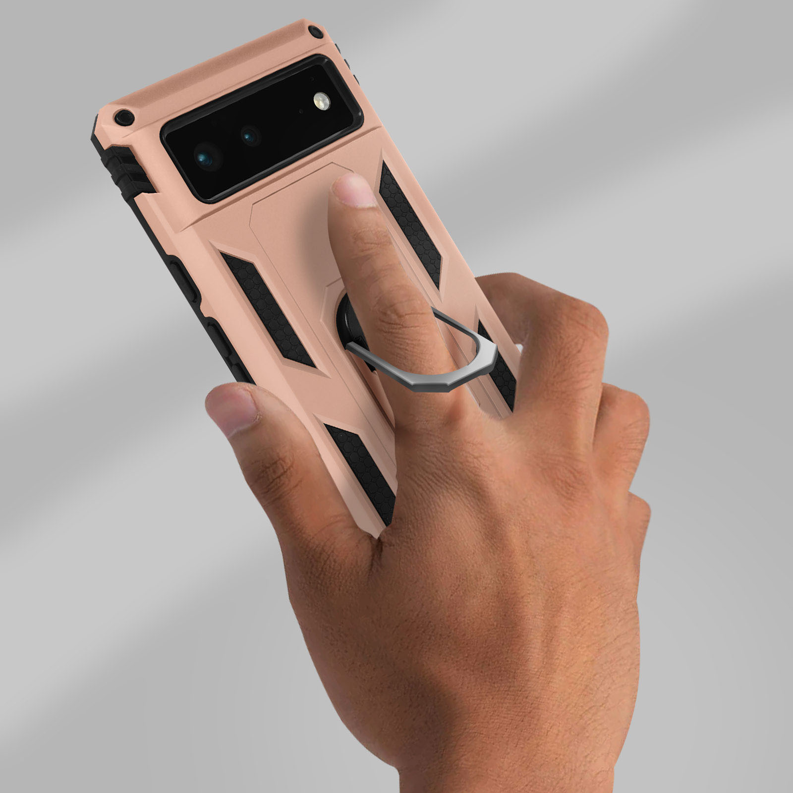 Een hand houdt een roségouden telefoonhoes met een ringhouder vast. Zwarte en gouden accenten.
