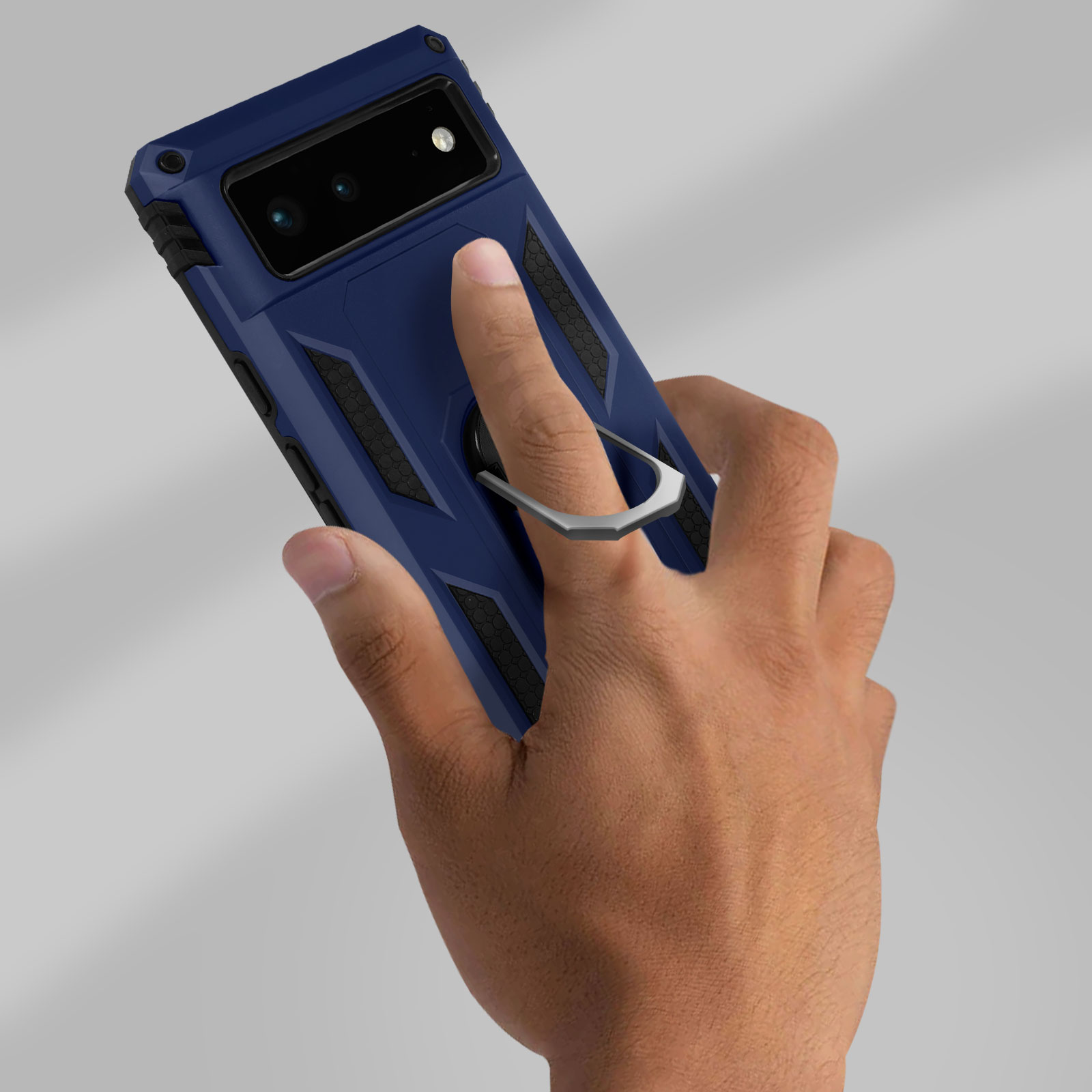 Mano che tiene una custodia blu con anello. Lo sfondo è una superficie neutra.